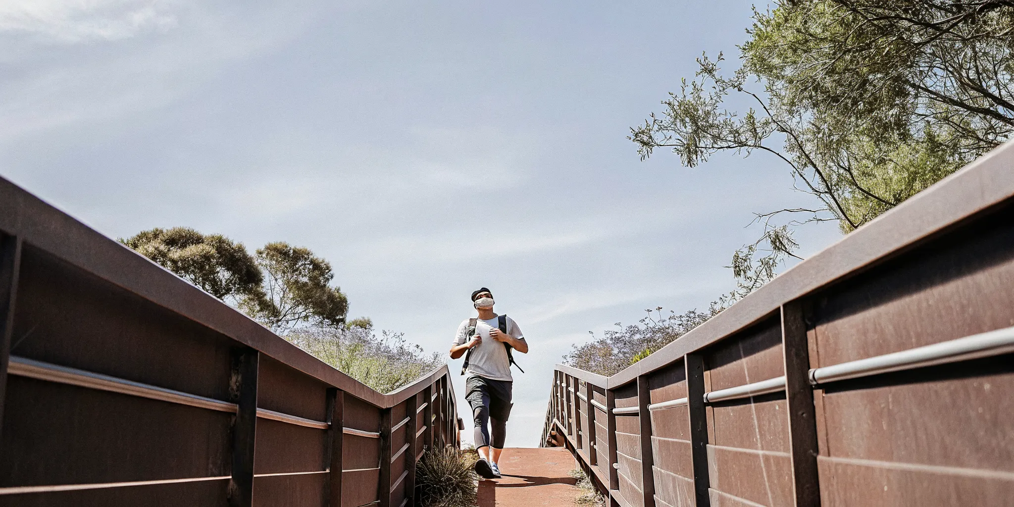Active middle-aged man walking on a sunlit nature trail, feeling energized and healthy