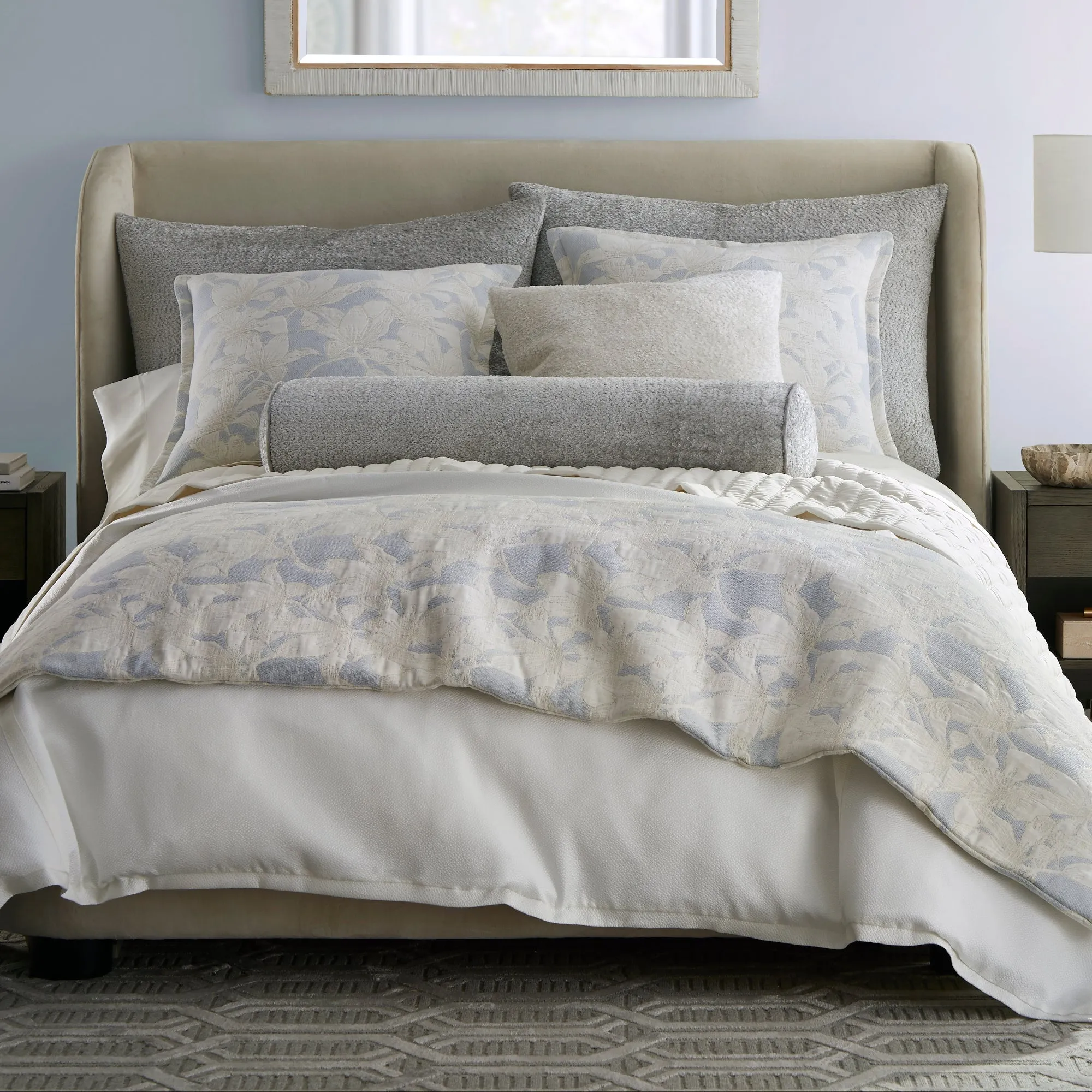 Pale blue layered bedding illustrating an elegant upholstered bed color palette