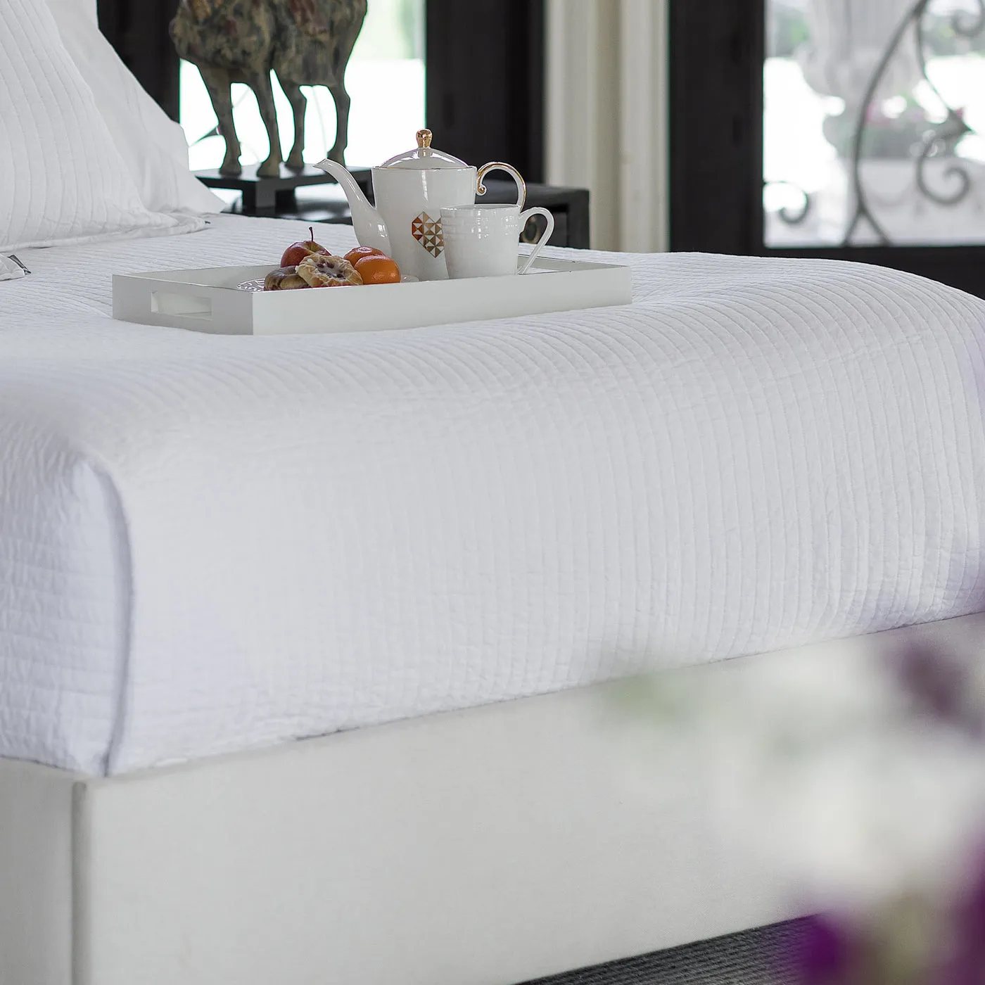 Tessa white linen quilted coverlet styled as a tailored luxury bedding layer