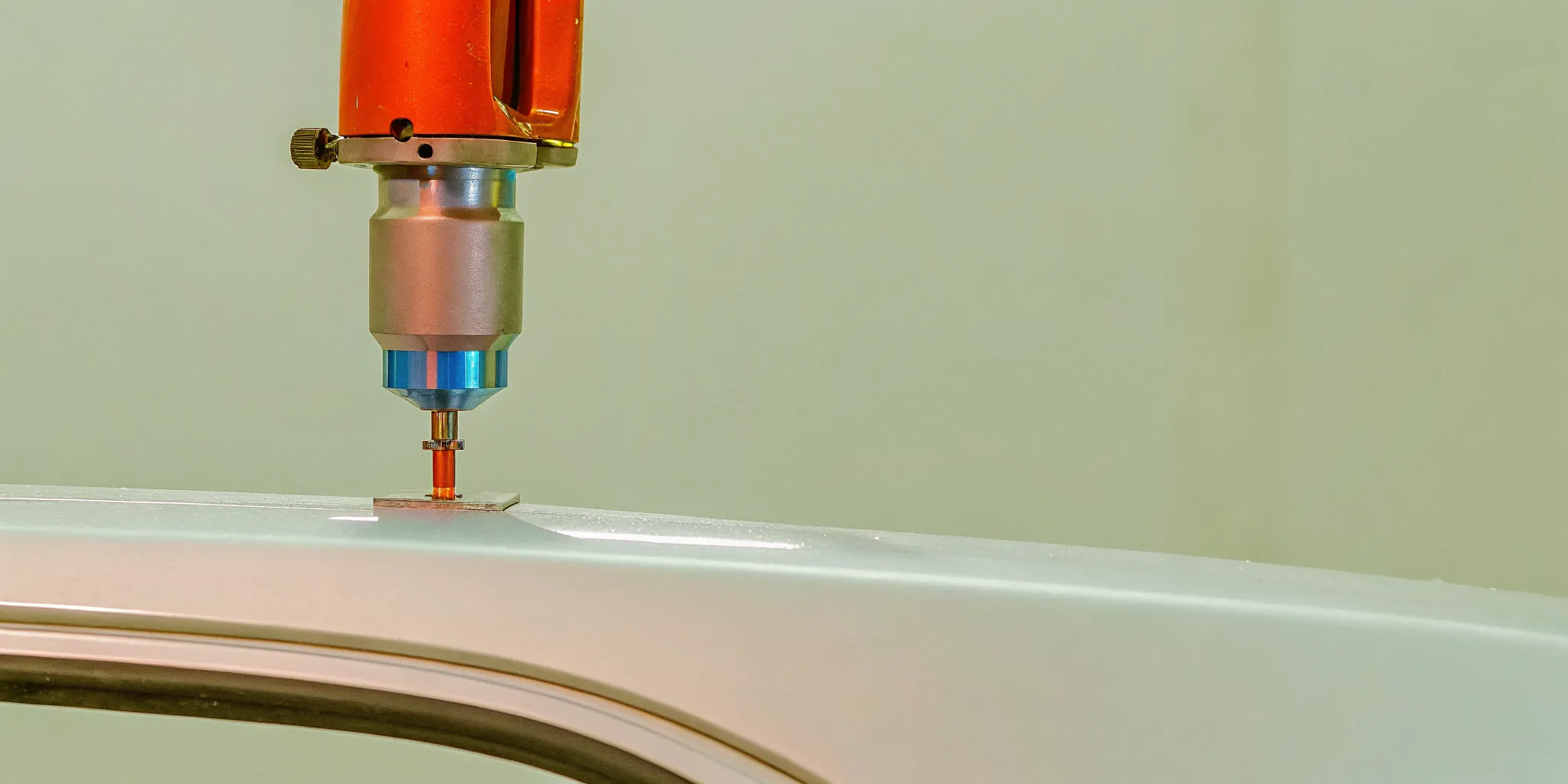 Auto body technician using specialized rivet bonding tool on an aluminum vehicle panel in a dedicated cleanroom workshop