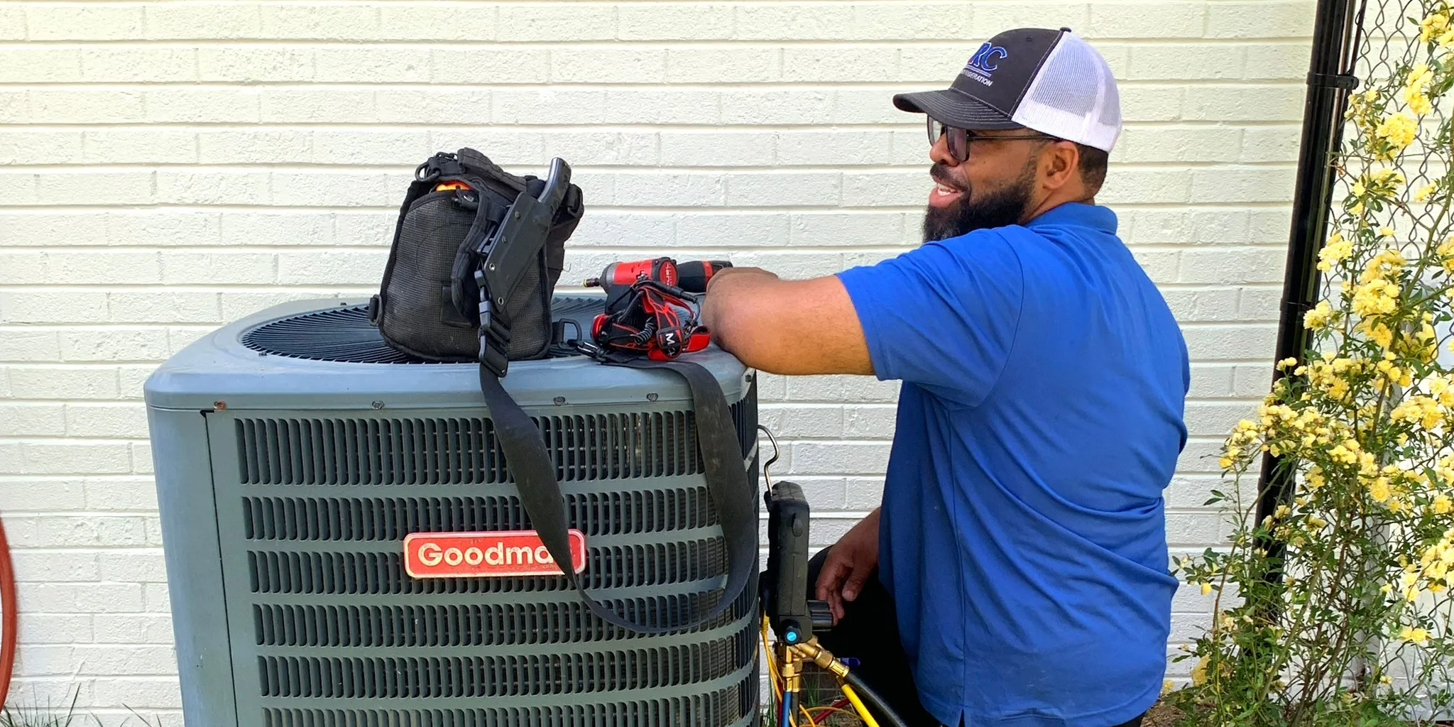 HVAC technician inspecting an outdoor heat pump condenser during maintenance in Clemmons NC