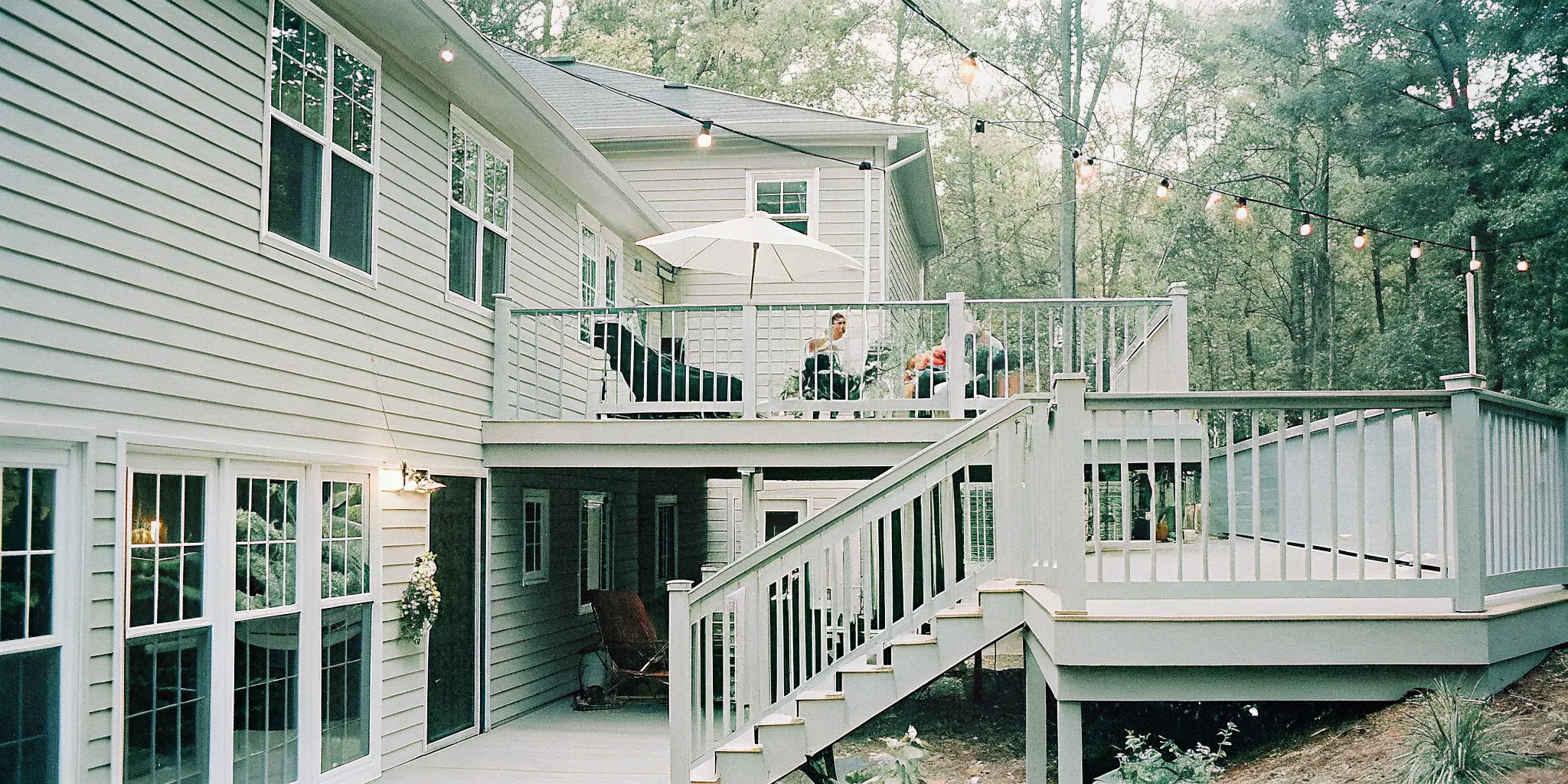 Multi-level composite deck with seating, pergola, and string lights in a Charlotte backyard