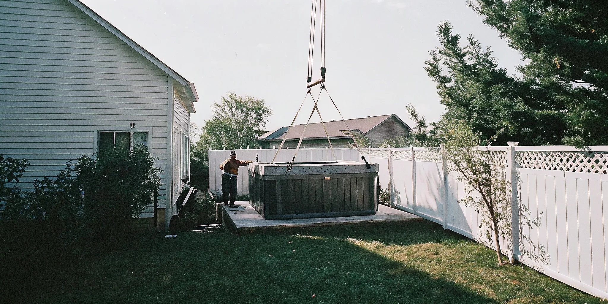 Hot tub being delivered and placed in a North Carolina backyard by professional installation crew