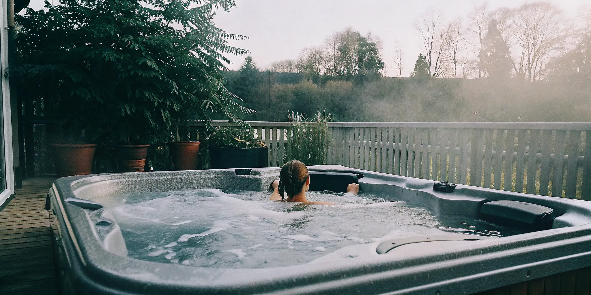 Person relaxing in a warm backyard hot tub