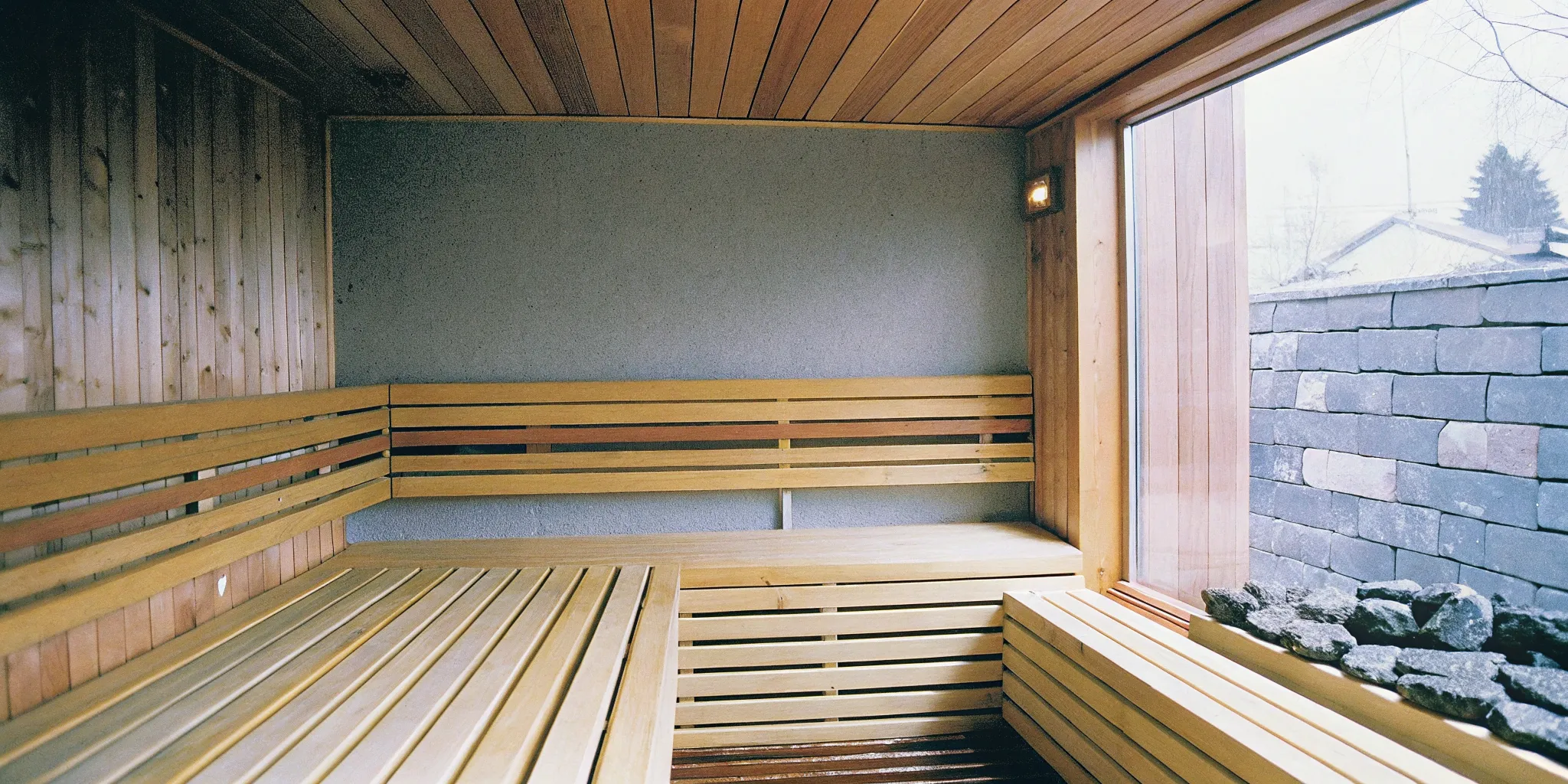 Traditional home sauna with wooden benches and heater stones