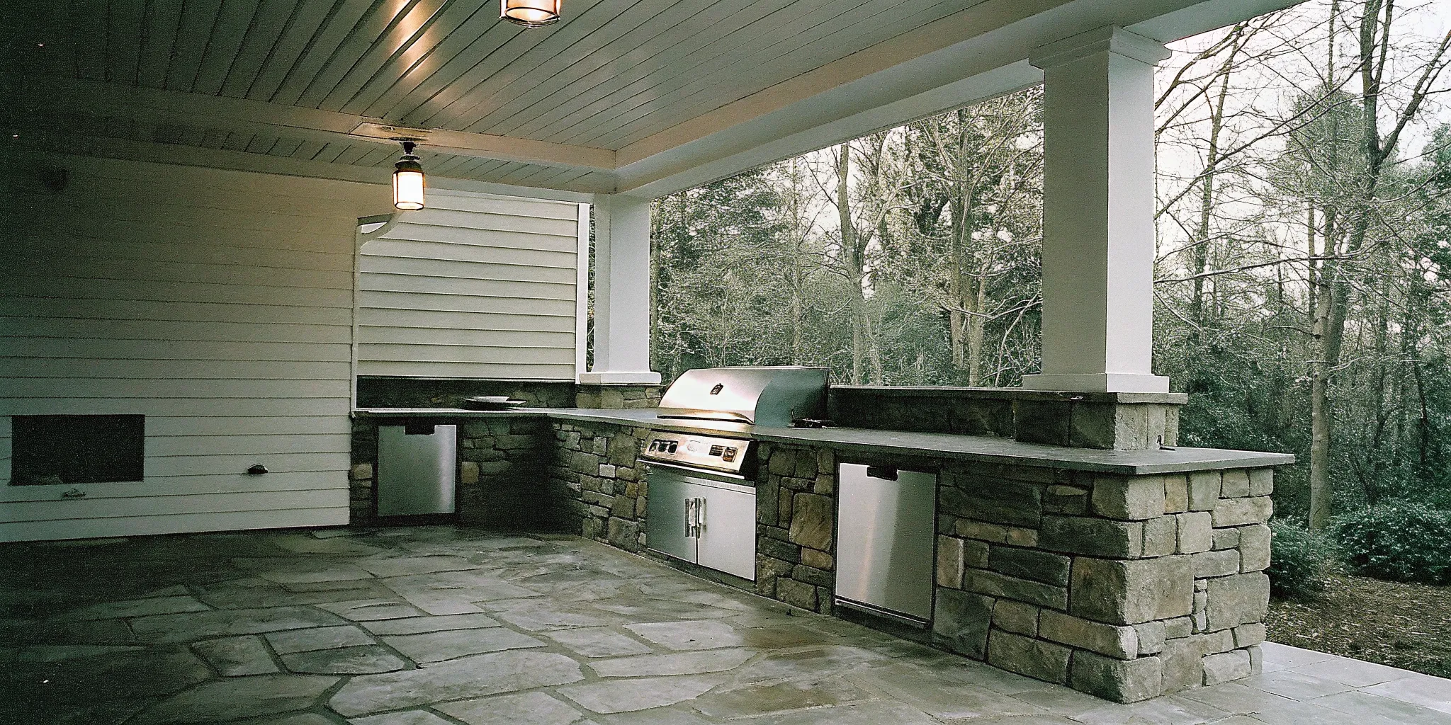 Covered patio outdoor kitchen with grill and vent hood for outdoor kitchen ventilation planning