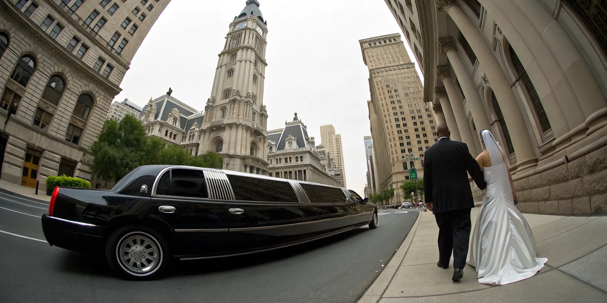 A wedding couple with their black limo in Philadelphia.