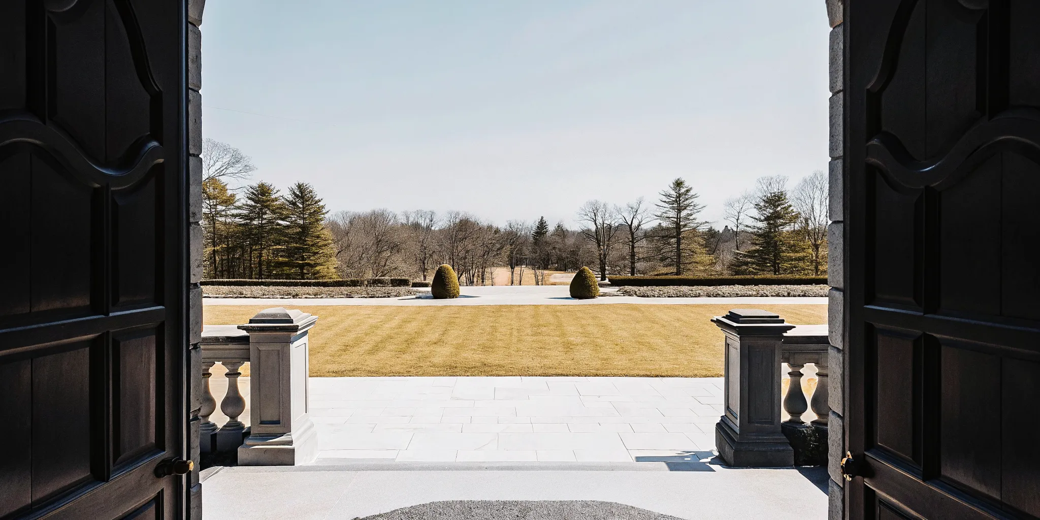 Expansive manicured lawn and gardens surrounding a French Chateau-style private estate in Dedham Massachusetts