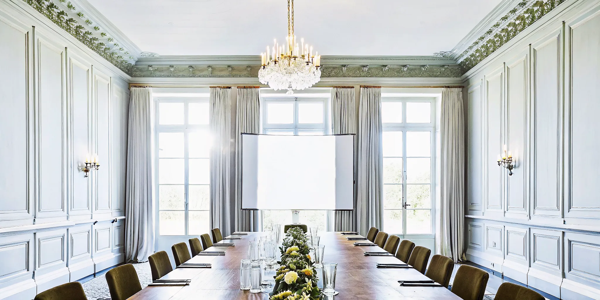 Elegant private dining room in a French chateau-style estate with a long table set for an executive dinner, soft lighting and refined atmosphere