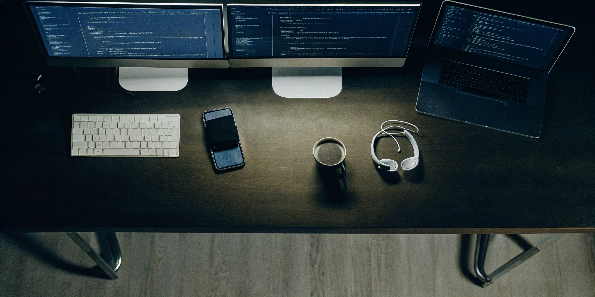 Secure IaC setup with dual monitors and laptop displaying code.