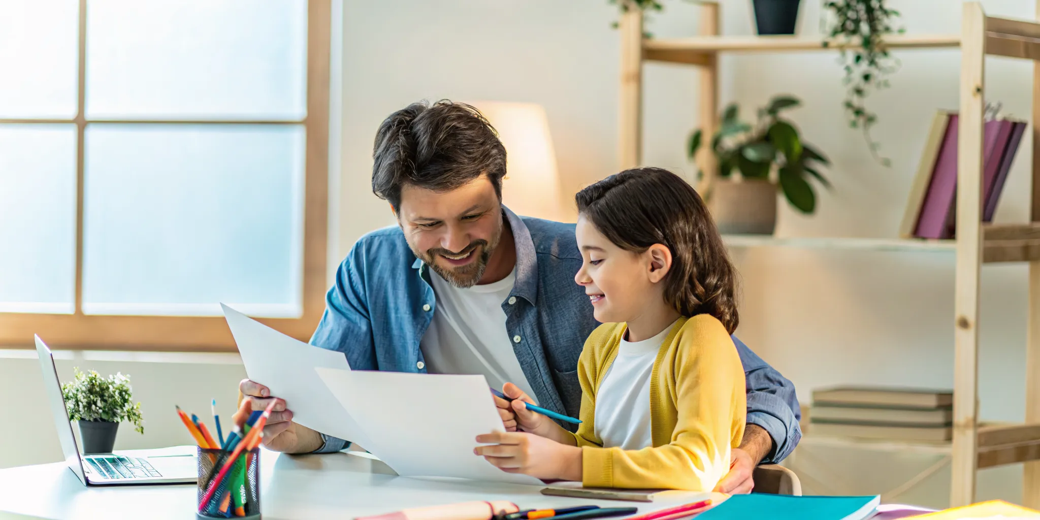 Parent and student reviewing school documents together at a home desk
