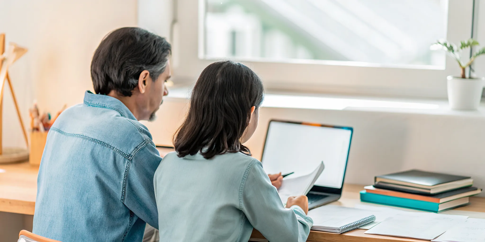 Parent and high school student reviewing online K-12 curriculum and school review pages together on a laptop