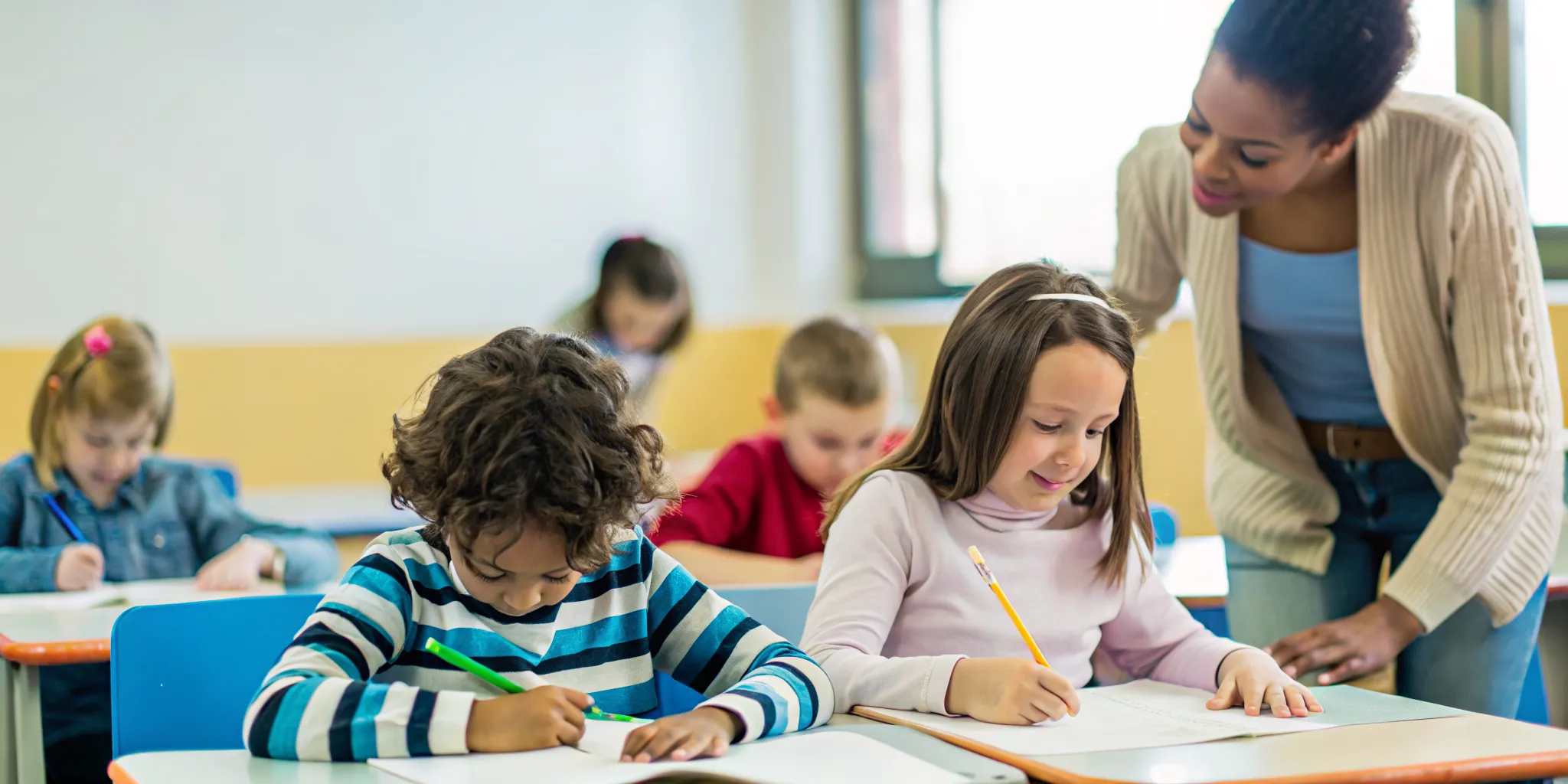 Diverse elementary students learning together in a bilingual dual-language classroom with their teacher