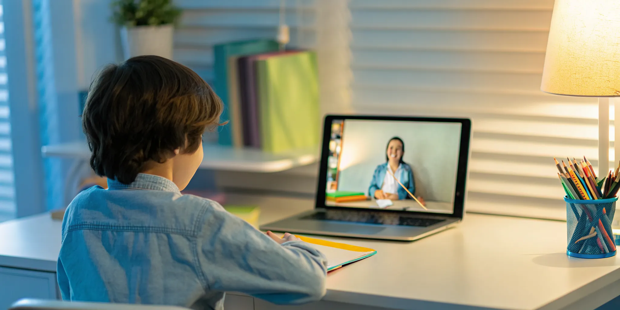 Elementary student attending a live online class at a bright home desk