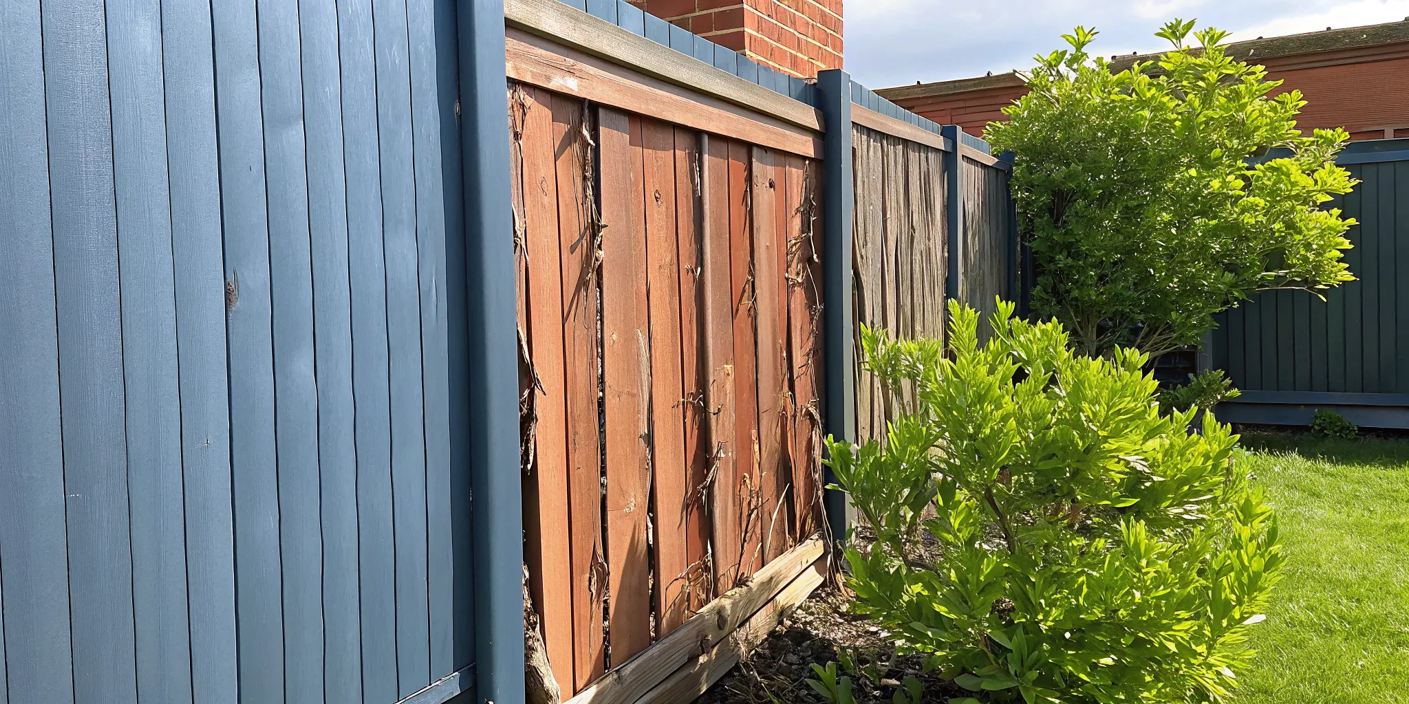 Rotting and weathered wooden fence contrasted with a durable composite fence panel installation