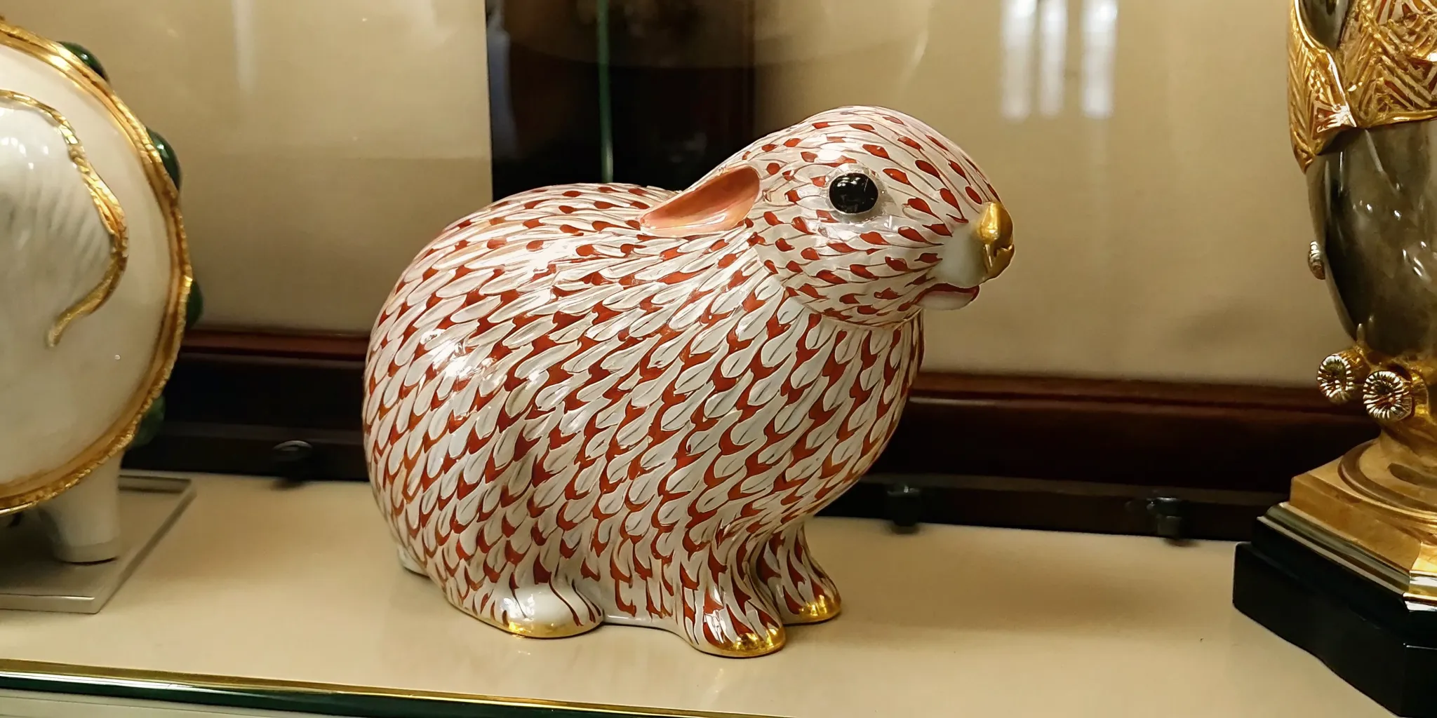 Close-up reference view of a hand-painted fishnet pattern on a porcelain animal figurine