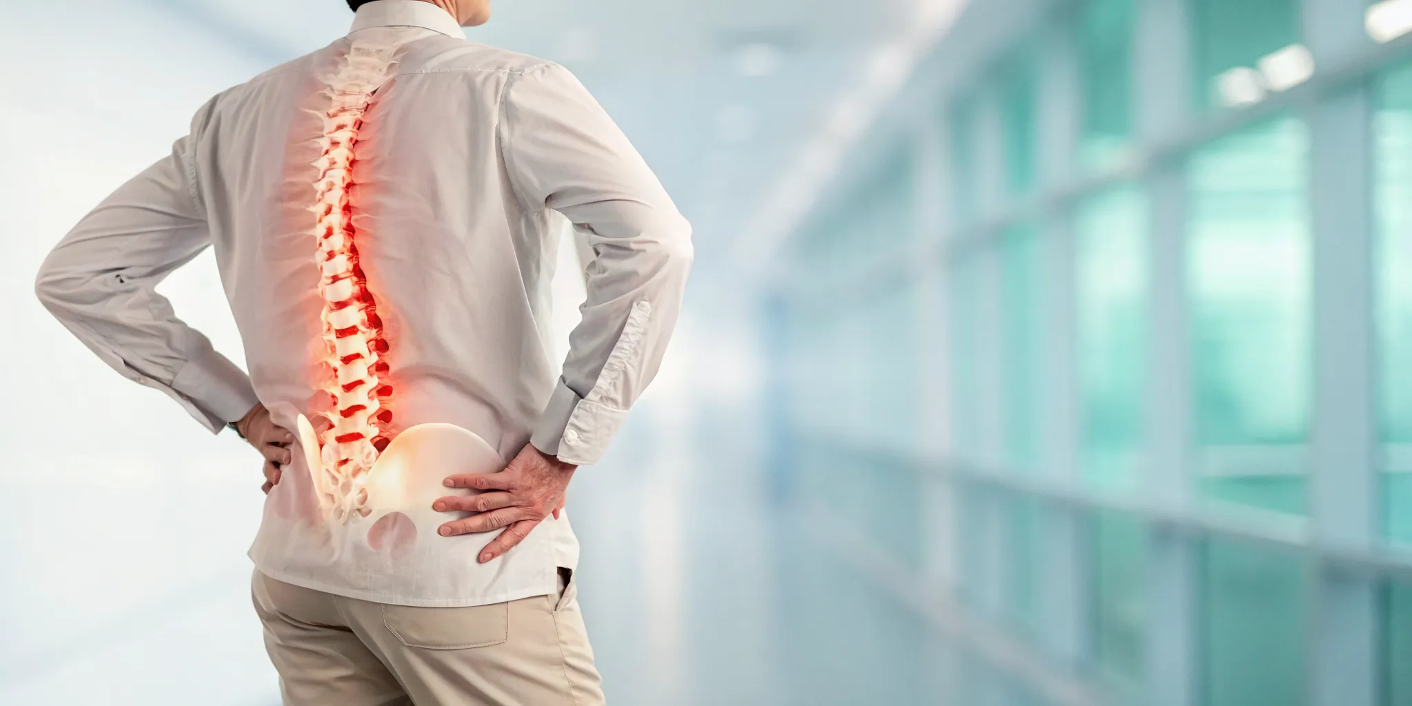 Man holding his lower back in pain, a sign of herniated disc emergency symptoms.