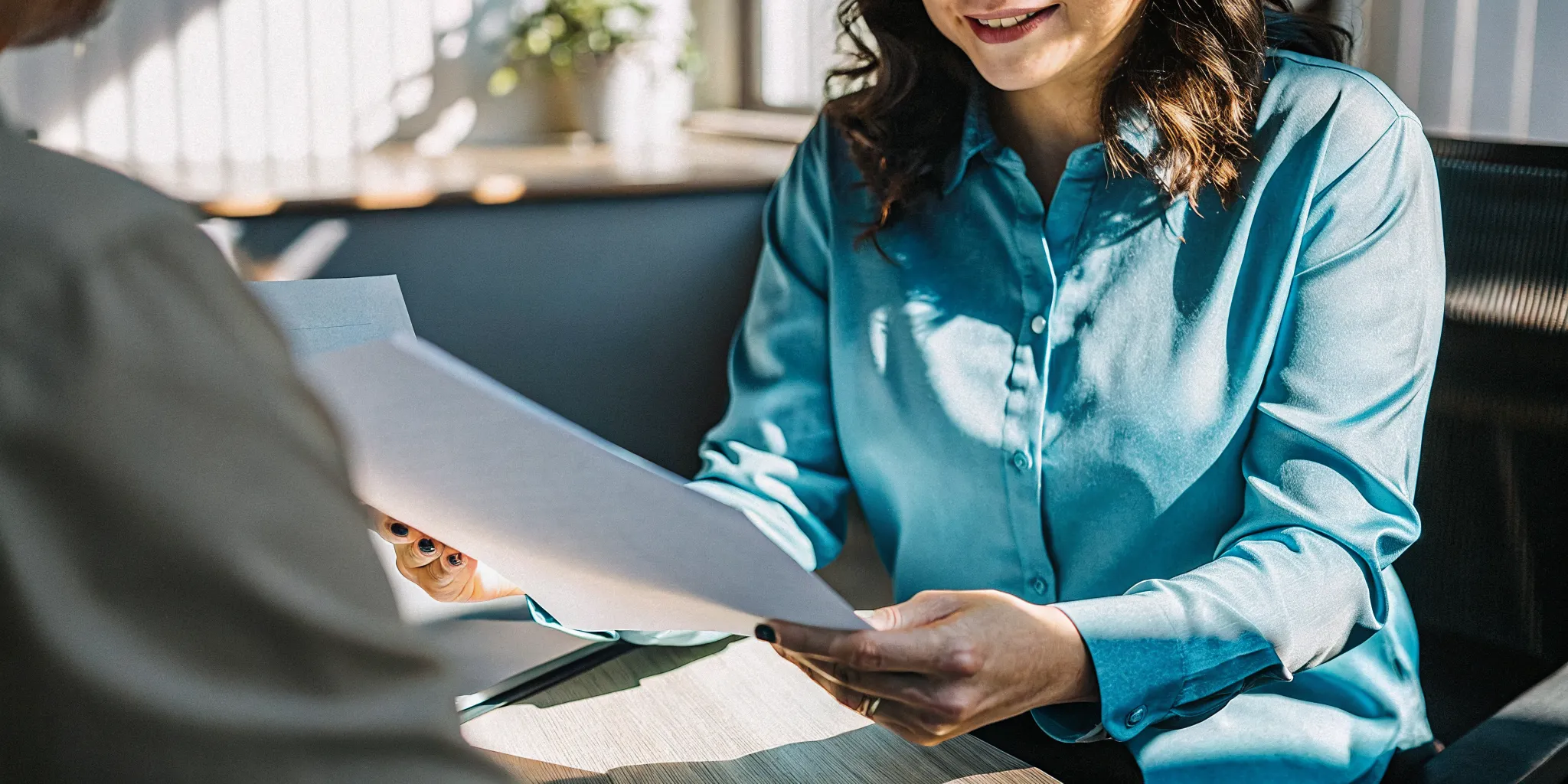 Document specialist reviewing a client's passport and visa paperwork in a bright office