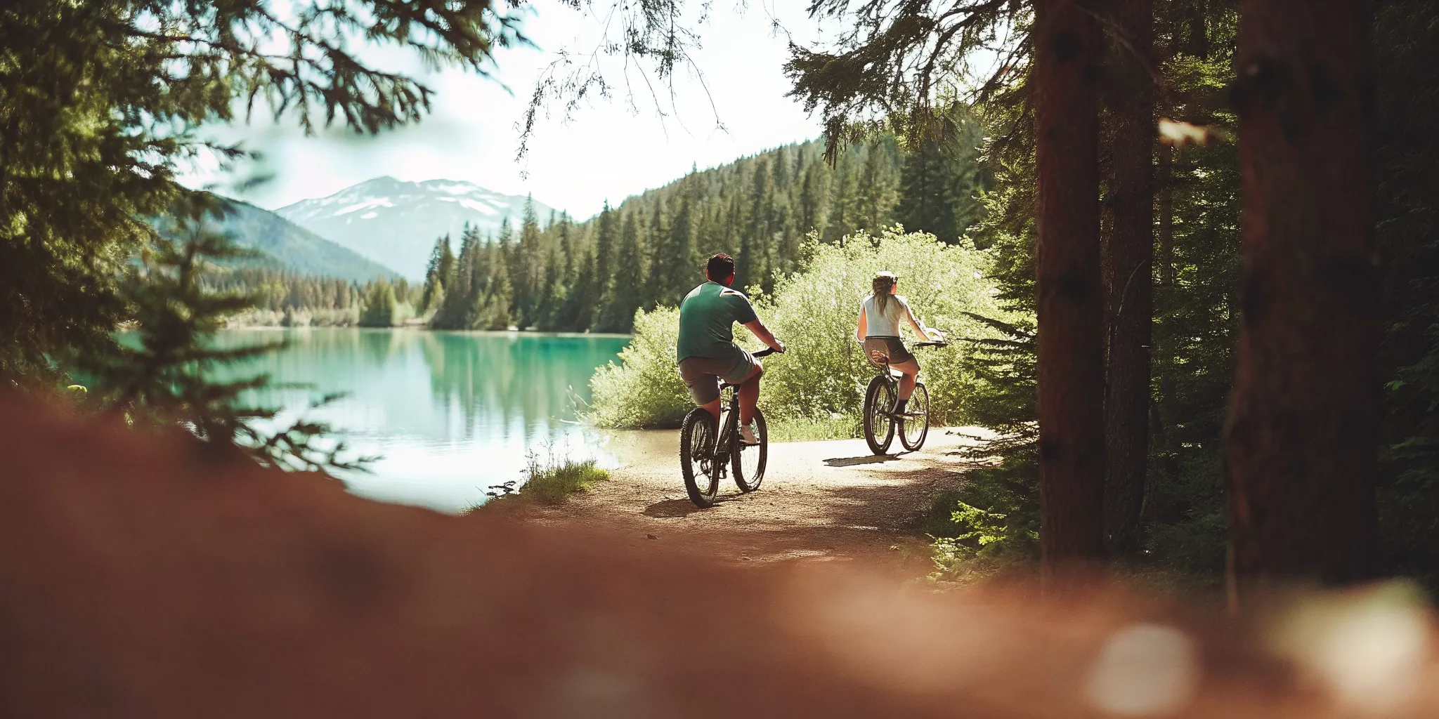 Riders on fat tire eBikes beside turquoise Green Lake in Whistler