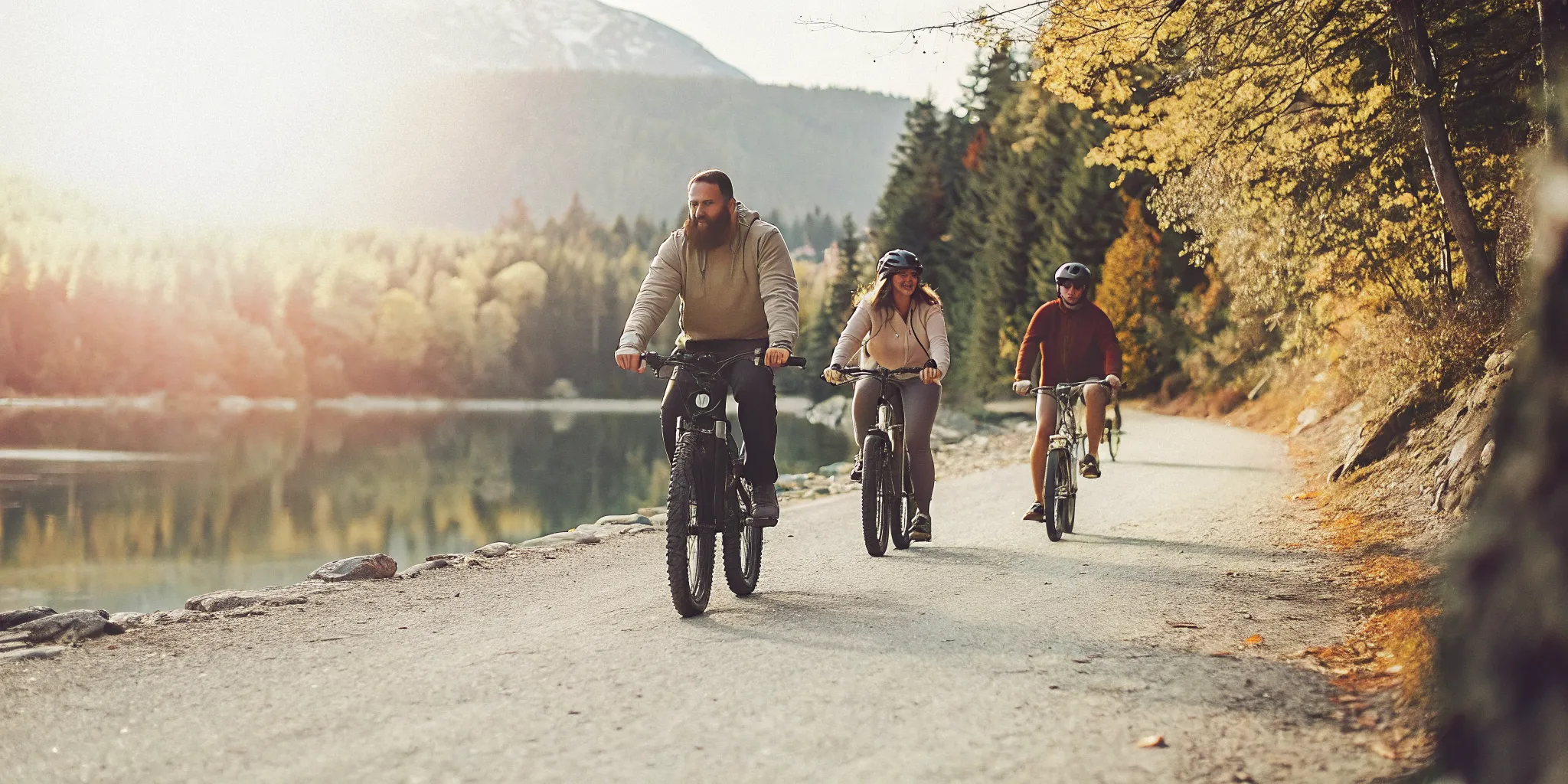 Group of riders on fat tire electric bikes on the Valley Trail in Whistler with golden September sunlight and amber fall foliage