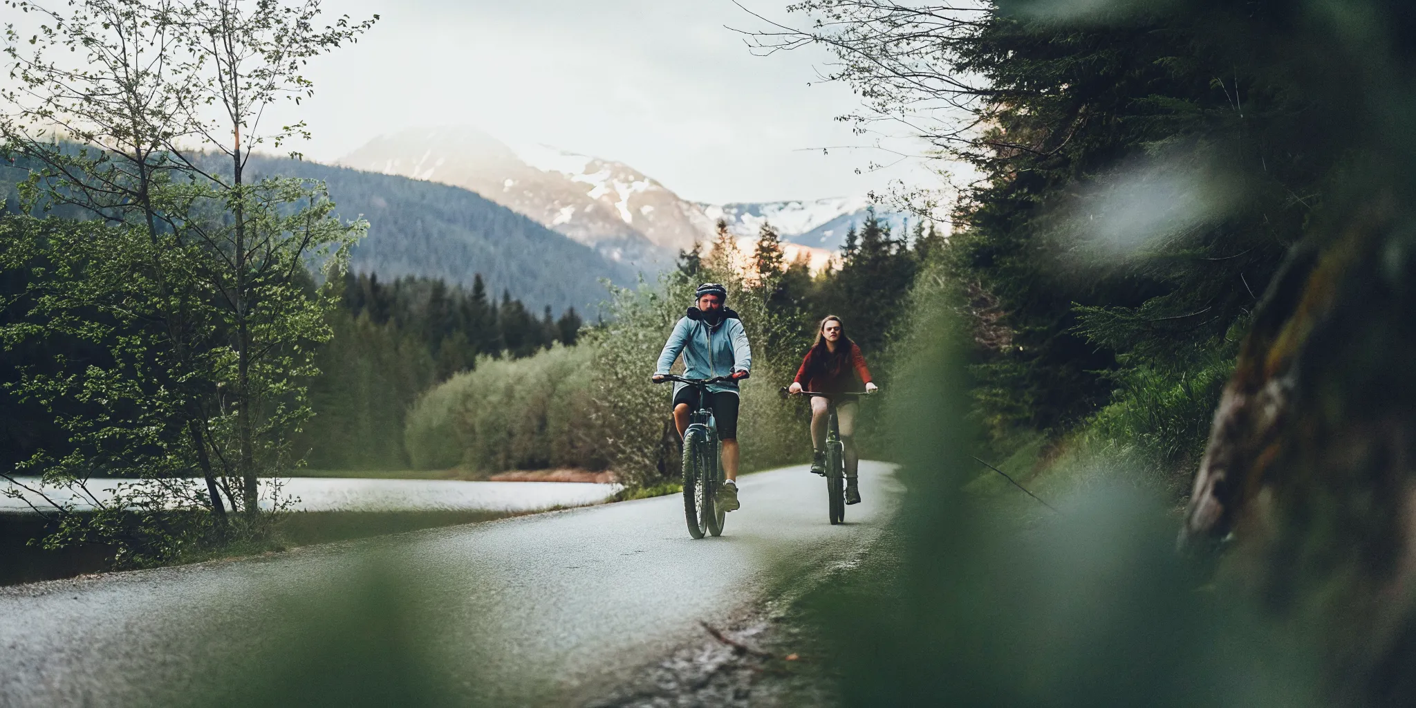 Riders on fat tire eBikes beside a glacier-fed lake along Whistler's Valley Trail