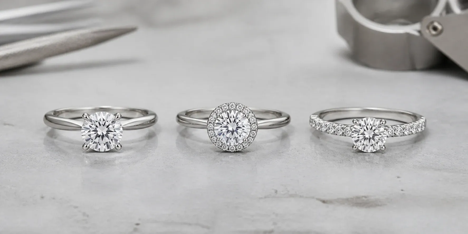 Solitaire, halo, and pavé diamond engagement rings on a jeweler’s workbench