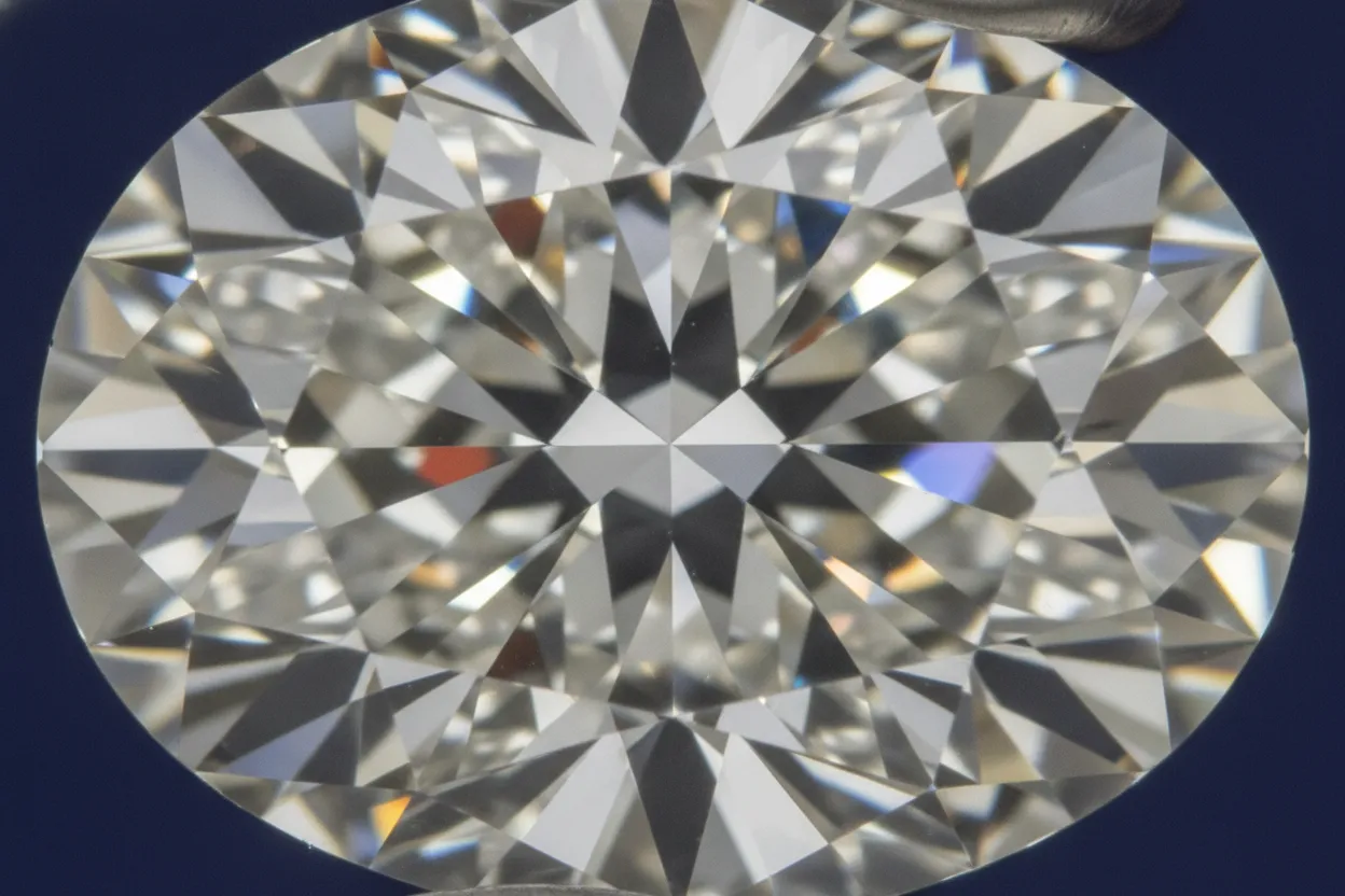 Close-up macro view of an oval diamond showing brilliant sparkle and facet light performance