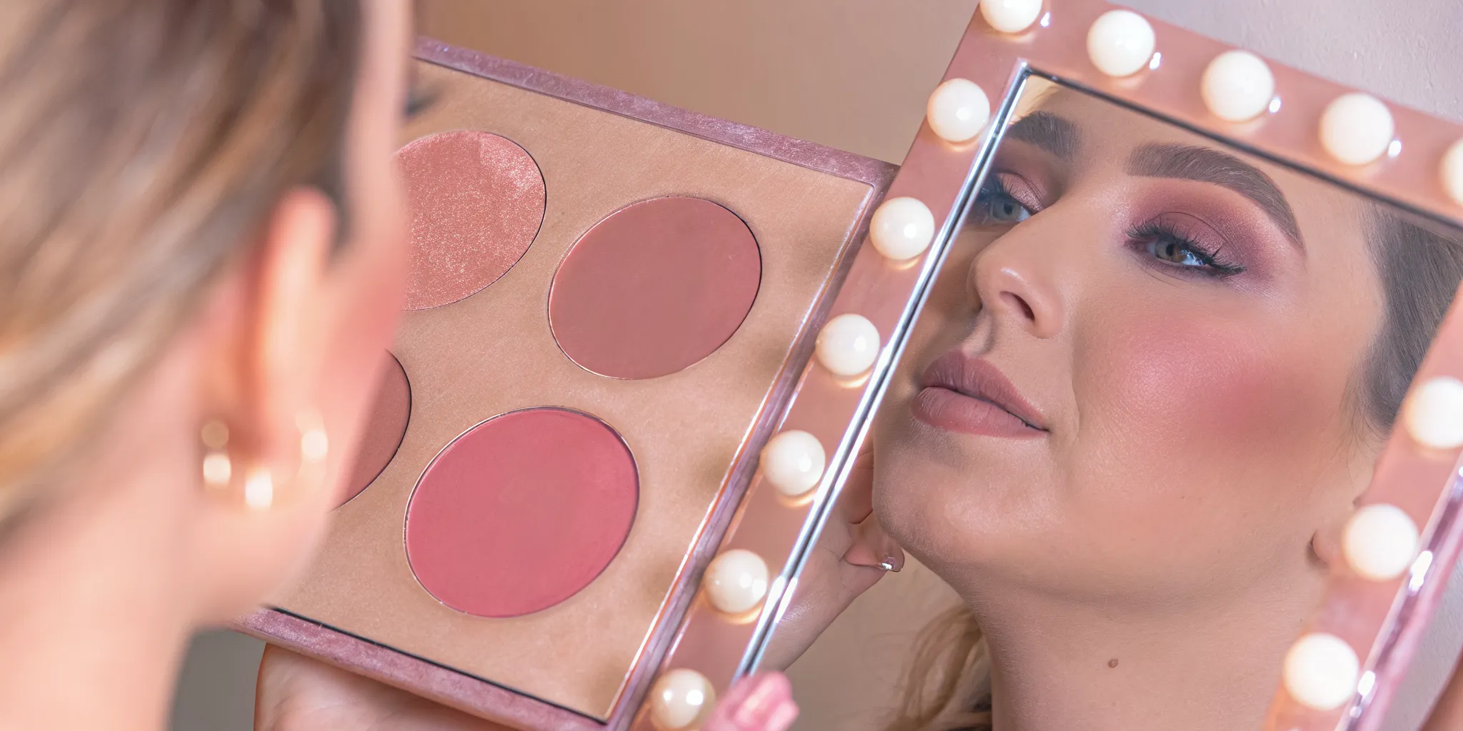 Woman applying a coordinated natural nude makeup look