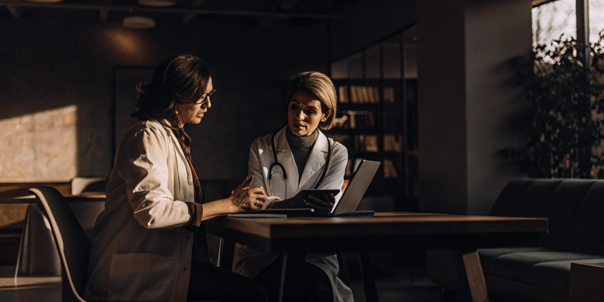 Physician meeting with a financial advisor in a bright office to discuss healthcare accounting