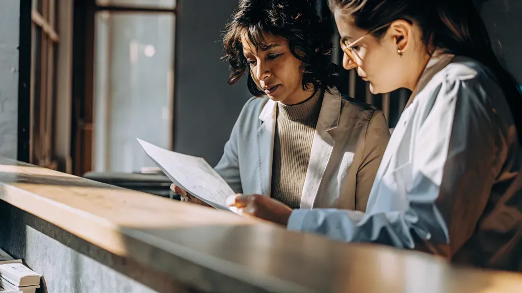 Healthcare practice bookkeeper and office manager reviewing an accounts receivable report together