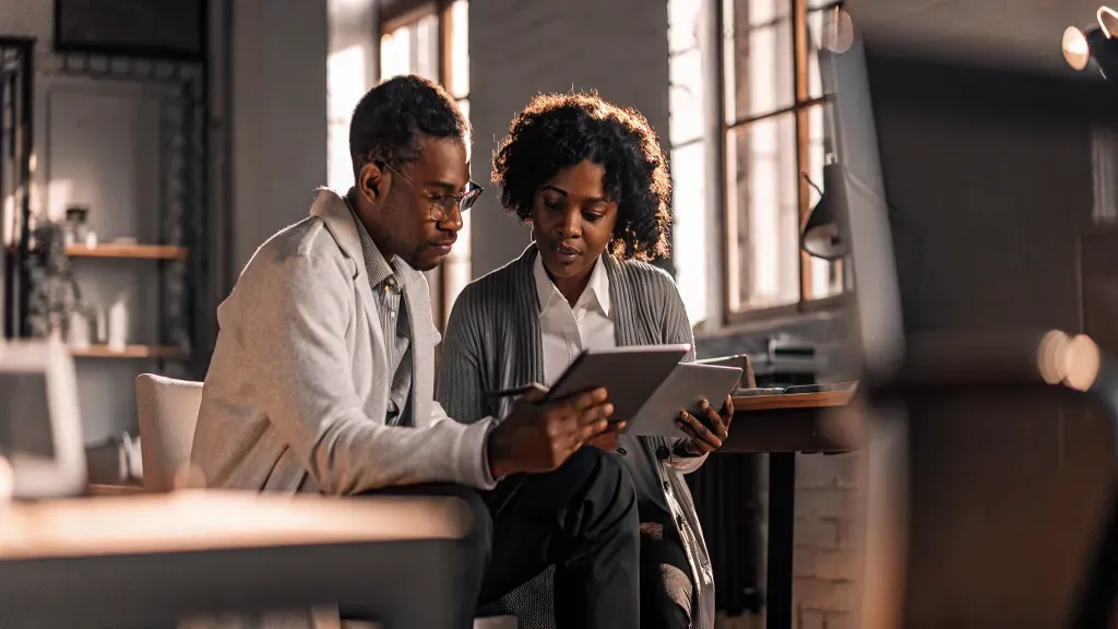 Medical practice owner and financial advisor reviewing a profit and loss report together
