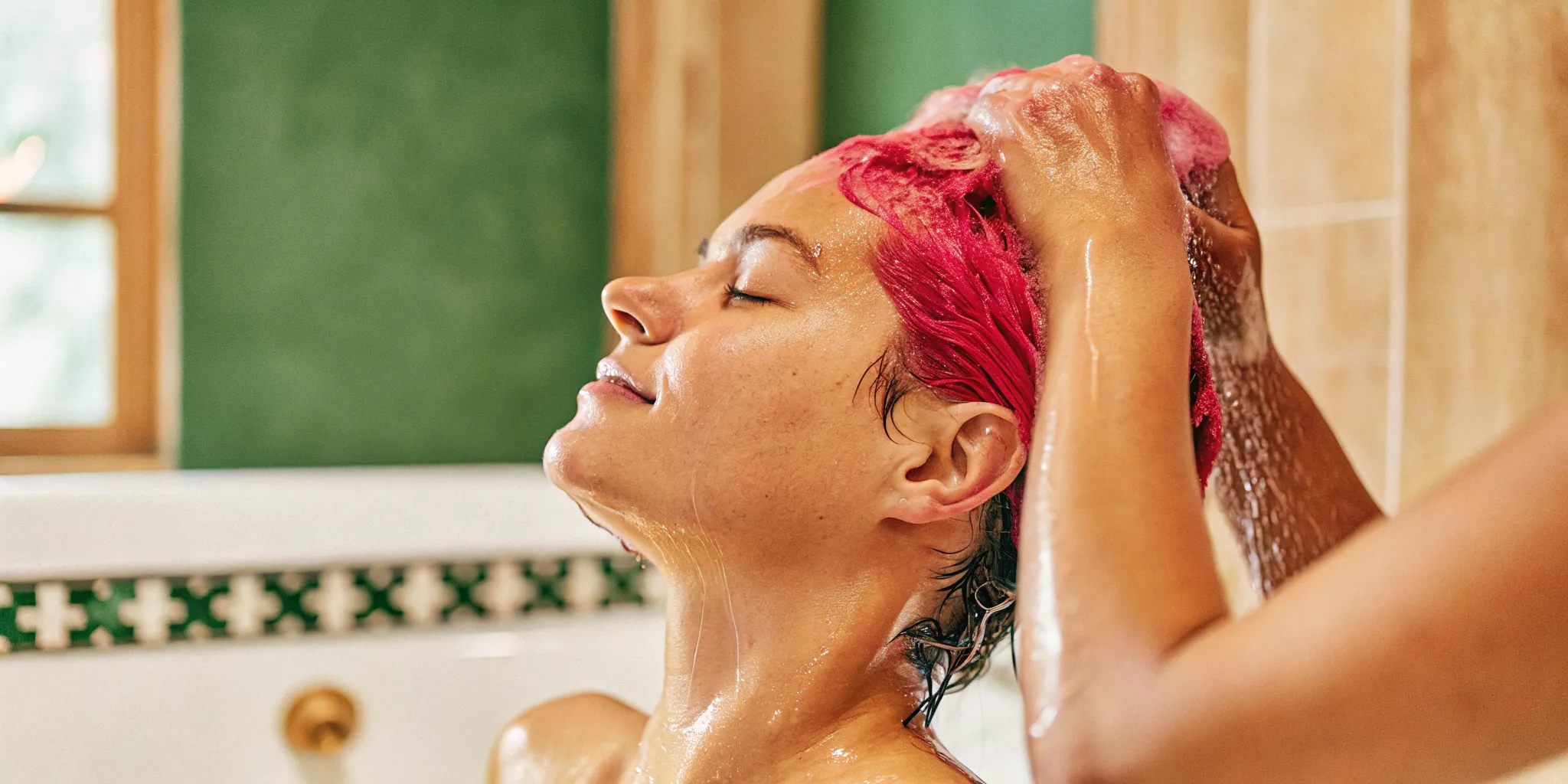 Woman rinsing color-treated hair with cool water to prevent hair dye from fading