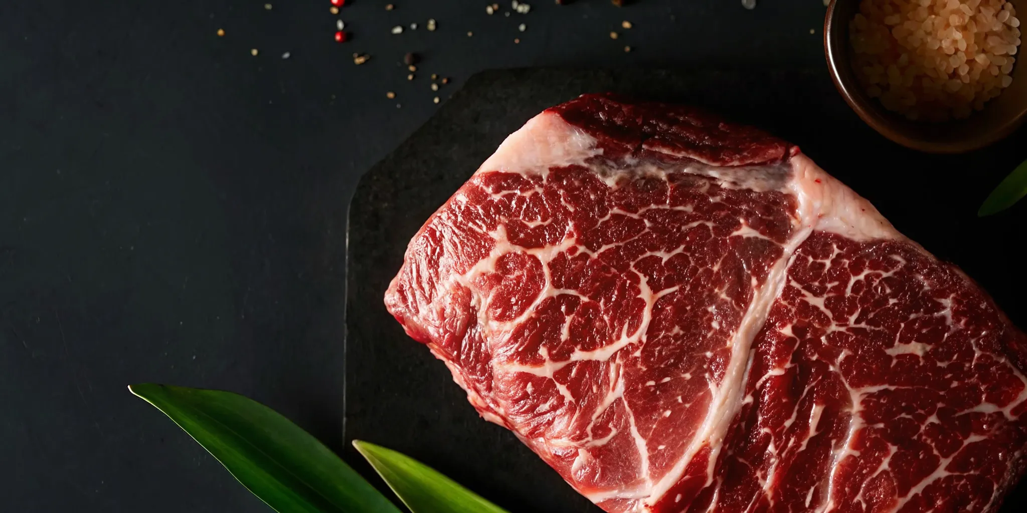Raw Fullblood Wagyu steak on a cutting board showing dense white marbling throughout the meat