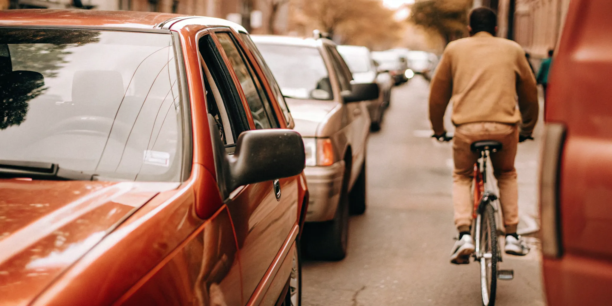 Cyclist riding safely beside parked cars on a South Carolina street