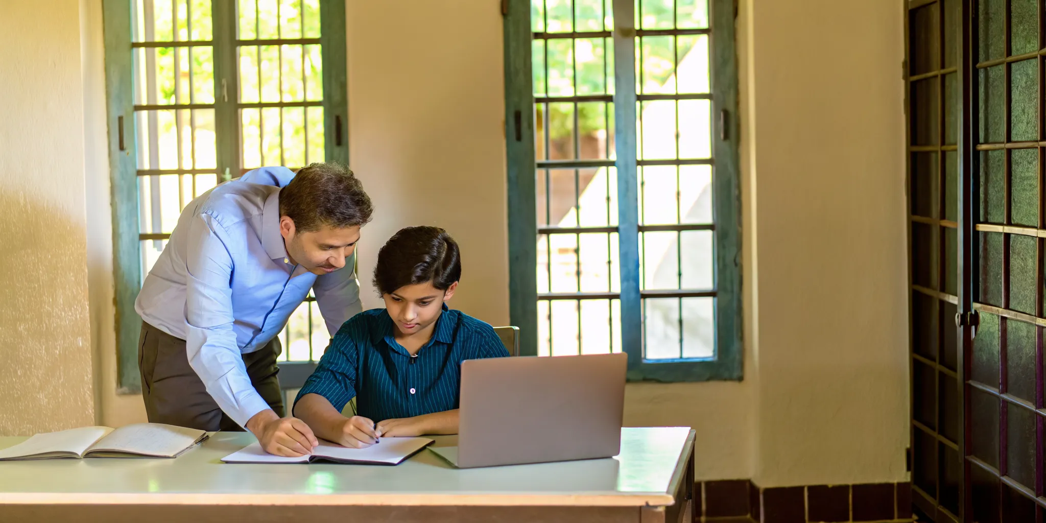 A tutor and student reviewing AP Calculus BC exam preparation material at a modern desk