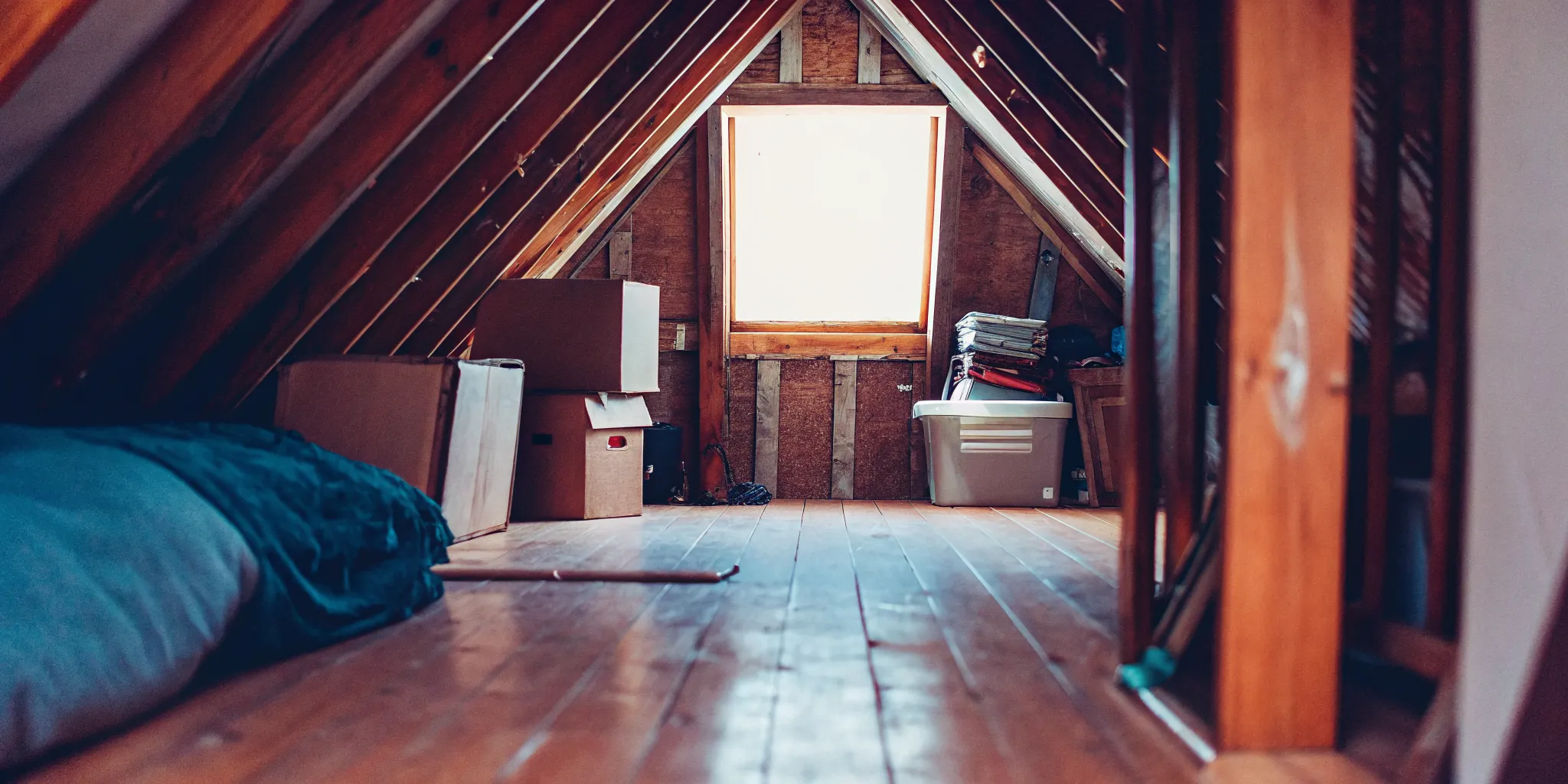 Residential attic with visible water stain on wooden beams showing moisture damage after rainfall in Central Valley