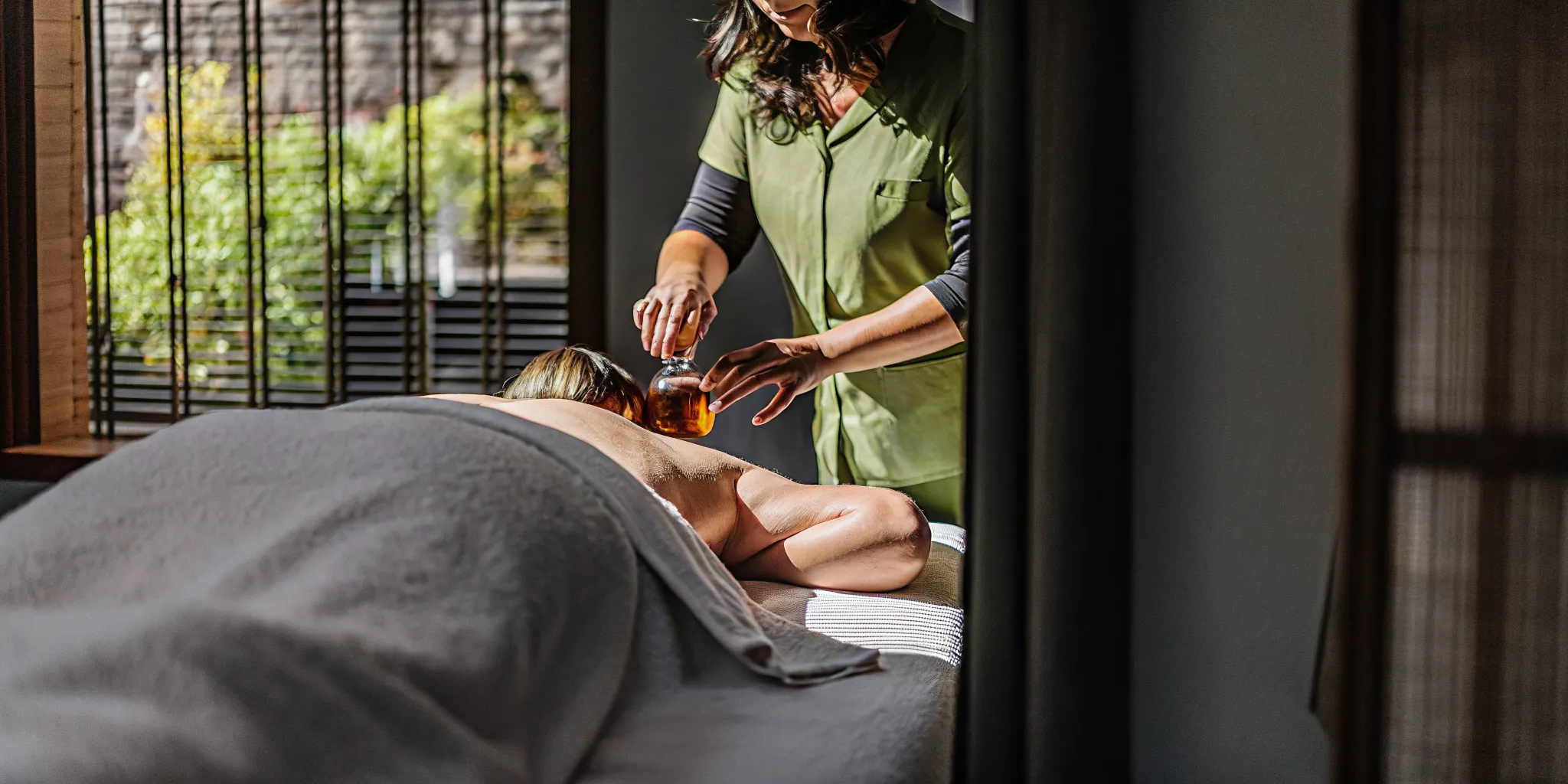 Therapist applying oil during a therapeutic massage session at a downtown New Orleans studio
