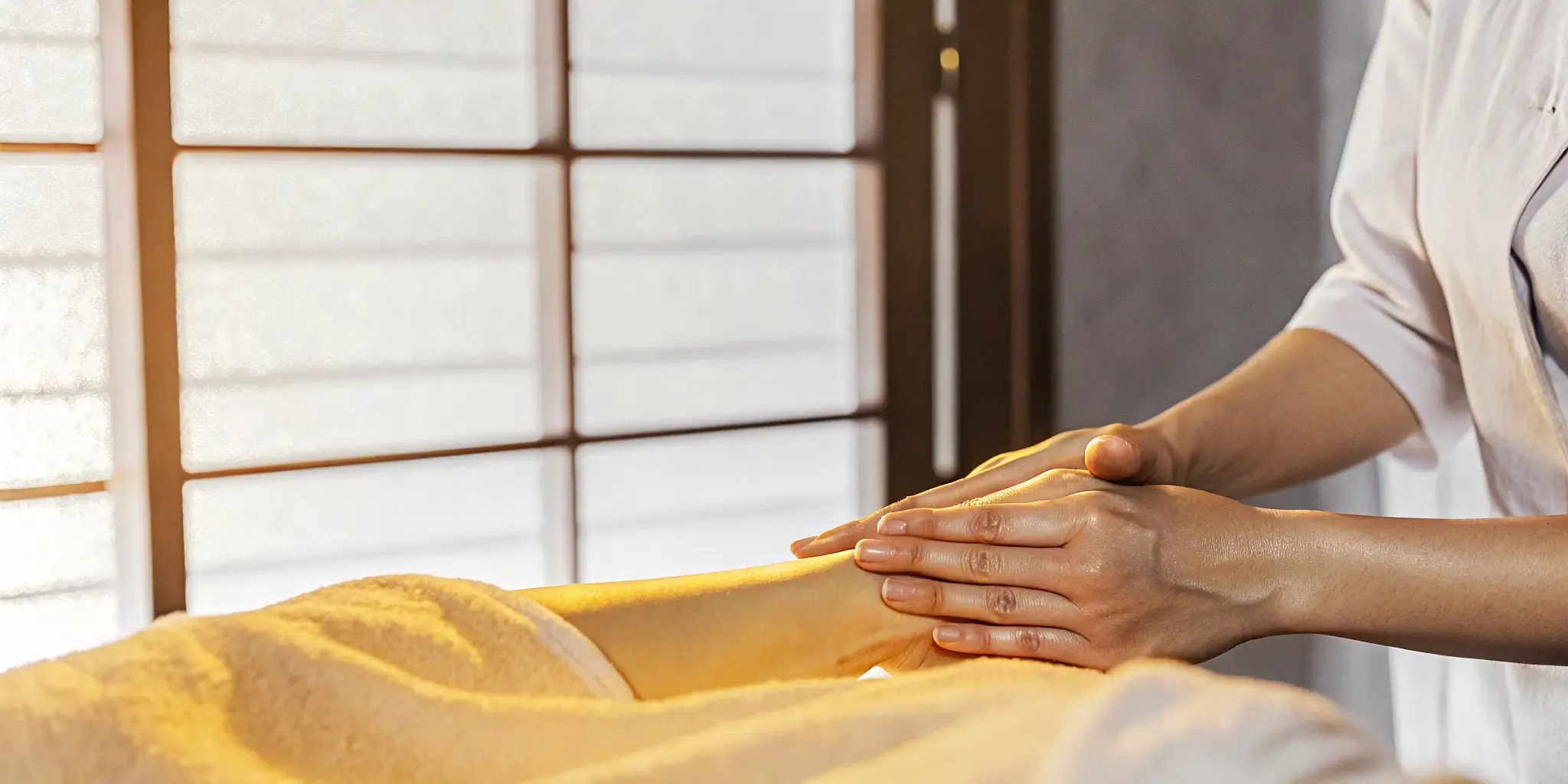 Massage therapist performing gentle lymphatic drainage strokes on a client in a peaceful New Orleans massage studio
