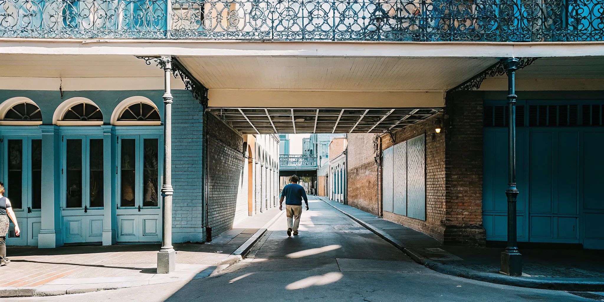 Historic Exchange Alley parking entrance near Lafayette Street in downtown New Orleans with pedestrian walking toward the warehouse district