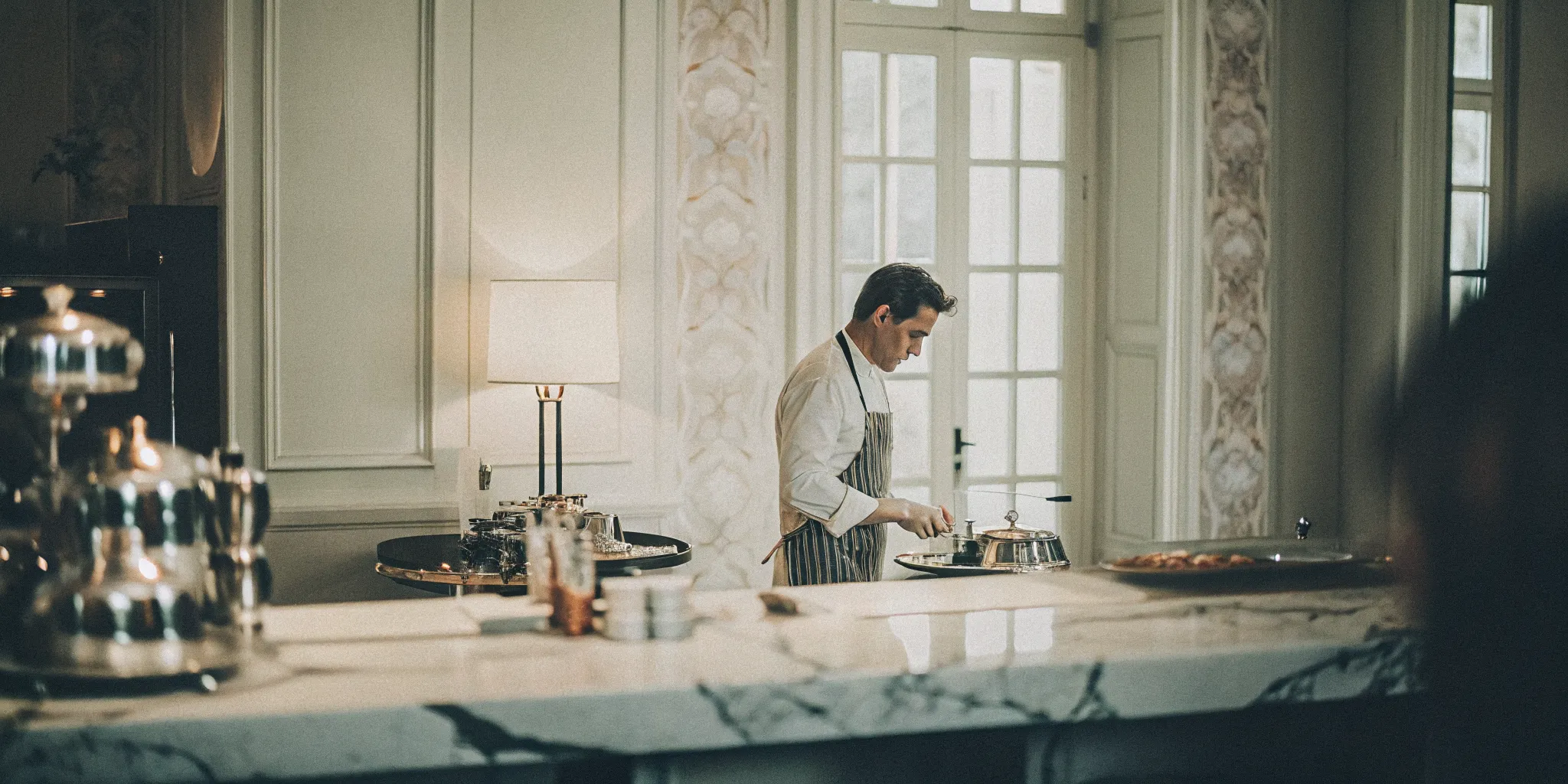 Private chef working in a gourmet estate kitchen with marble countertops and professional equipment