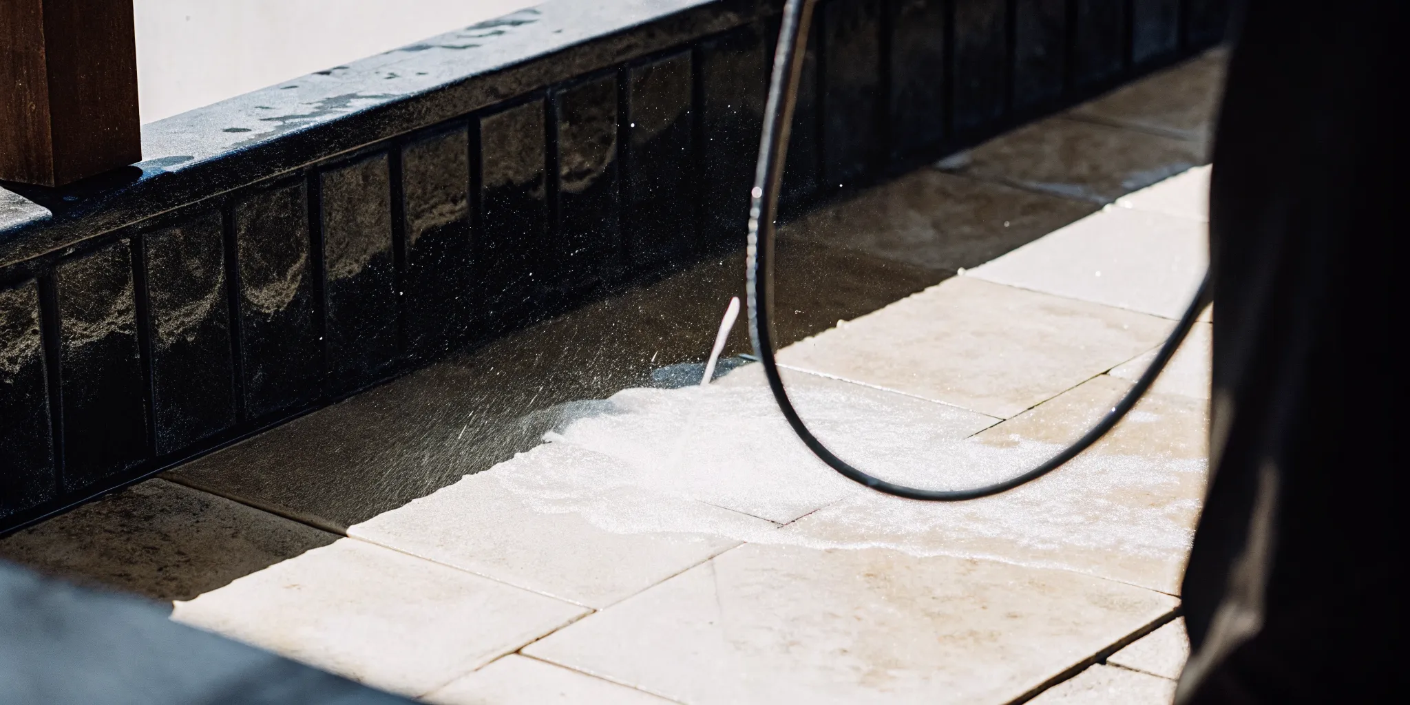 Clean travertine surface being rinsed and maintained beside a pool