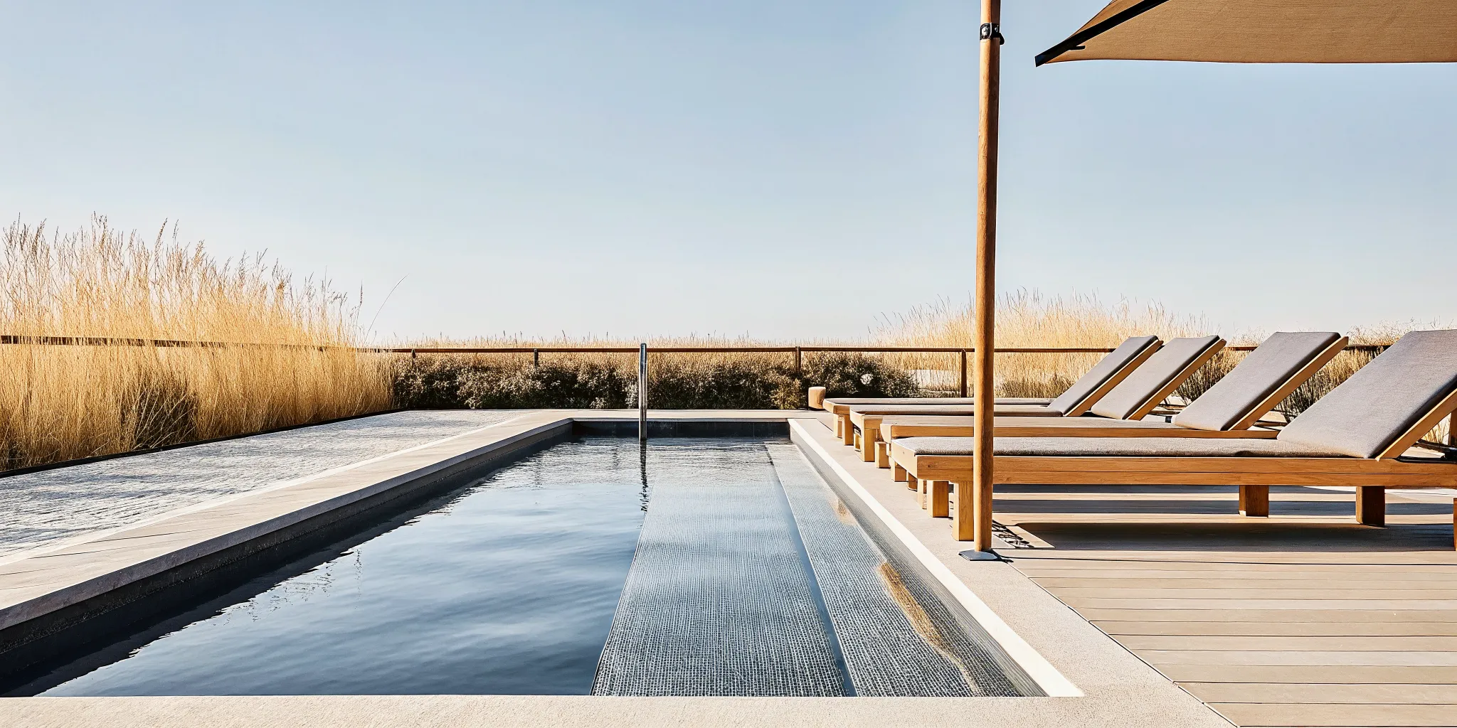 Completed gunite swimming pool with natural stone coping and travertine deck in a landscaped Long Island backyard
