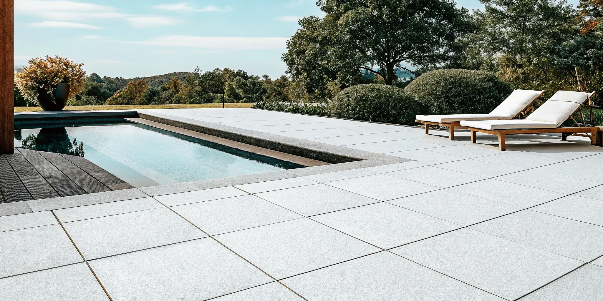 Light gray large-format porcelain pavers installed around a modern residential pool deck