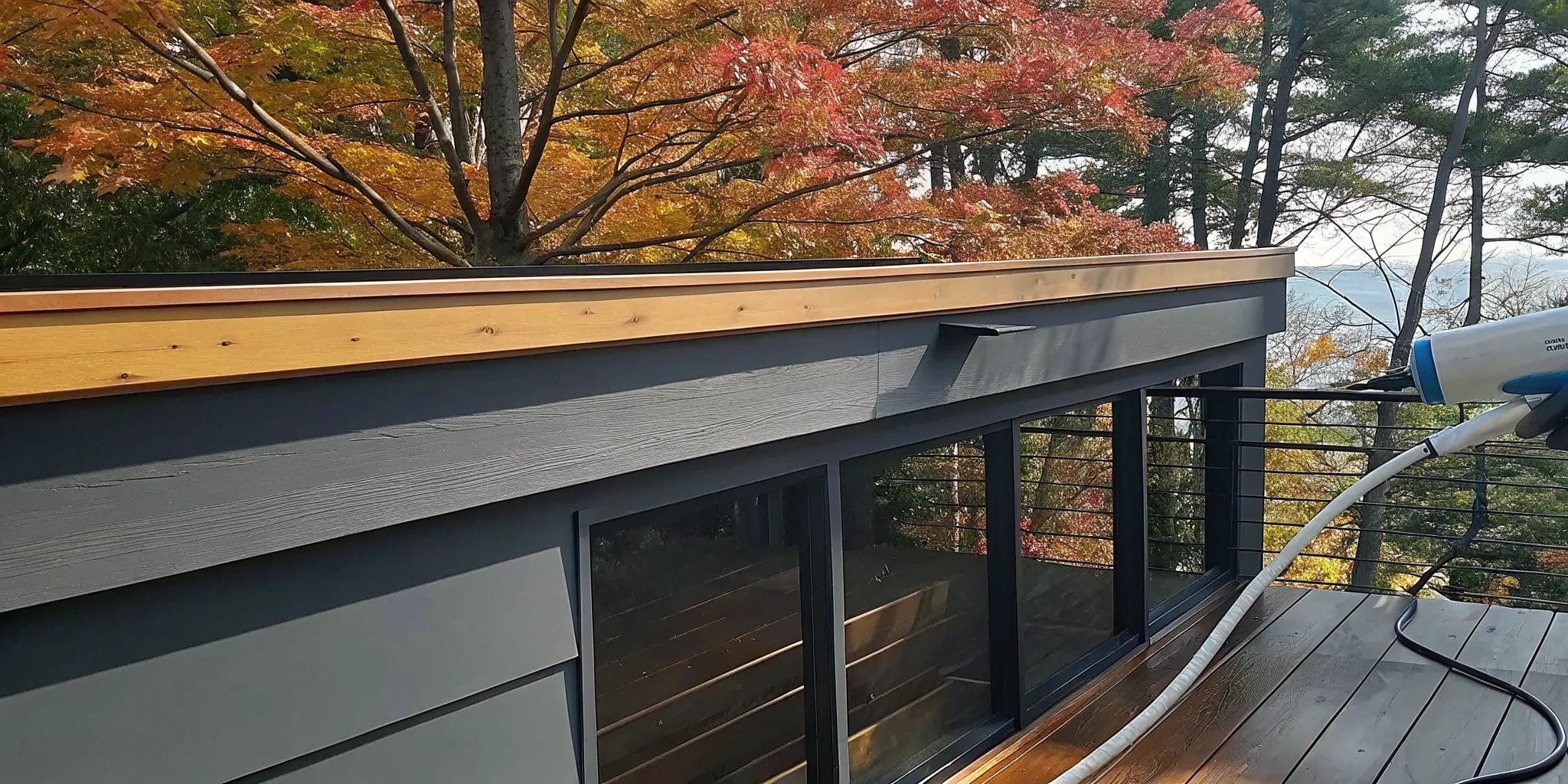 Professional applying protective oil to a cedar deck on a Long Island property in autumn
