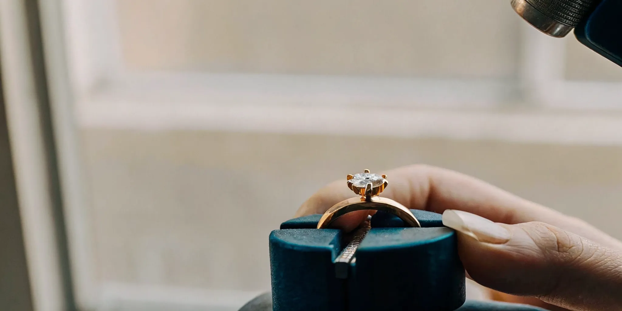 Master jeweler setting a diamond into a second marriage engagement ring at the workbench