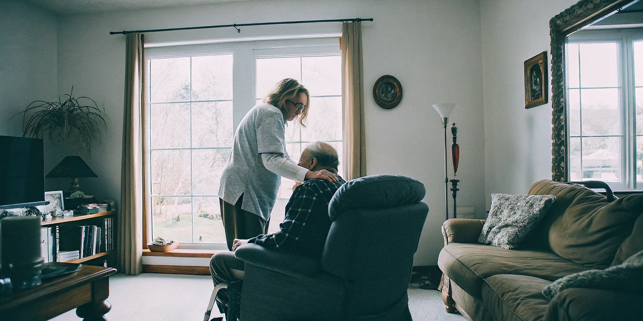 A caregiver gently guiding an older veteran in a bright living room during in-home senior care in Aurora