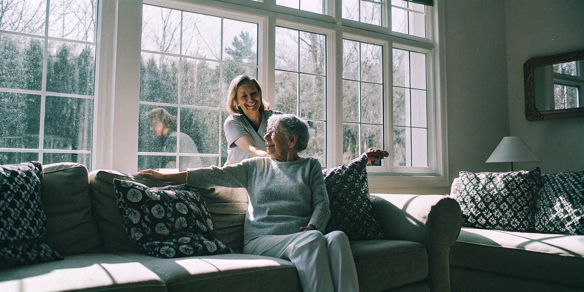 Caregiver guiding a senior woman through gentle stretching exercises in a bright living room