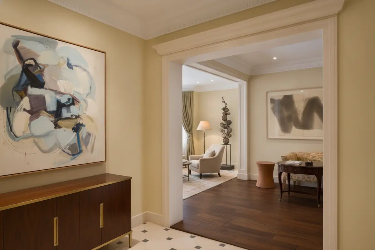A painting, framed work on paper, and sculpture displayed together under layered lighting in a private residence.