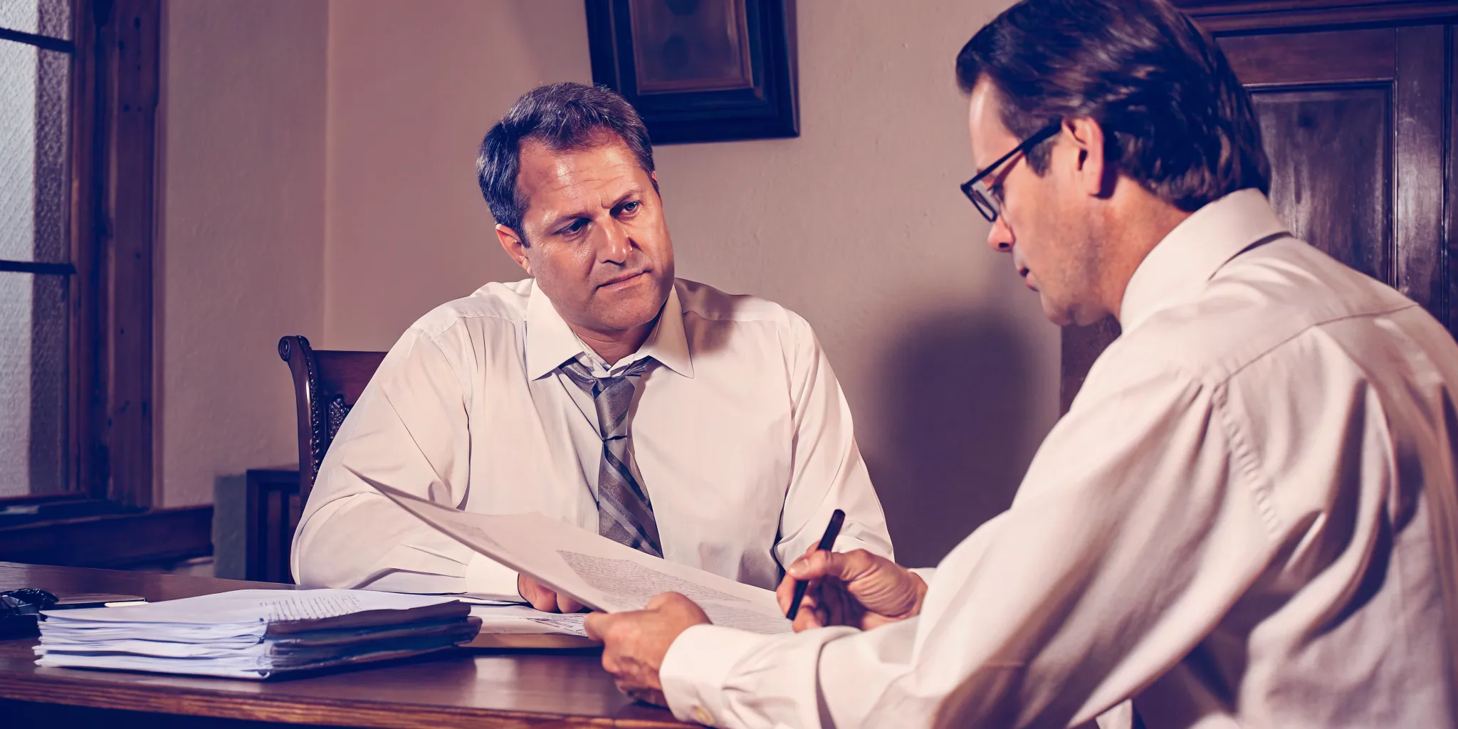 Illinois attorney reviewing client funding documents at desk in professional law office