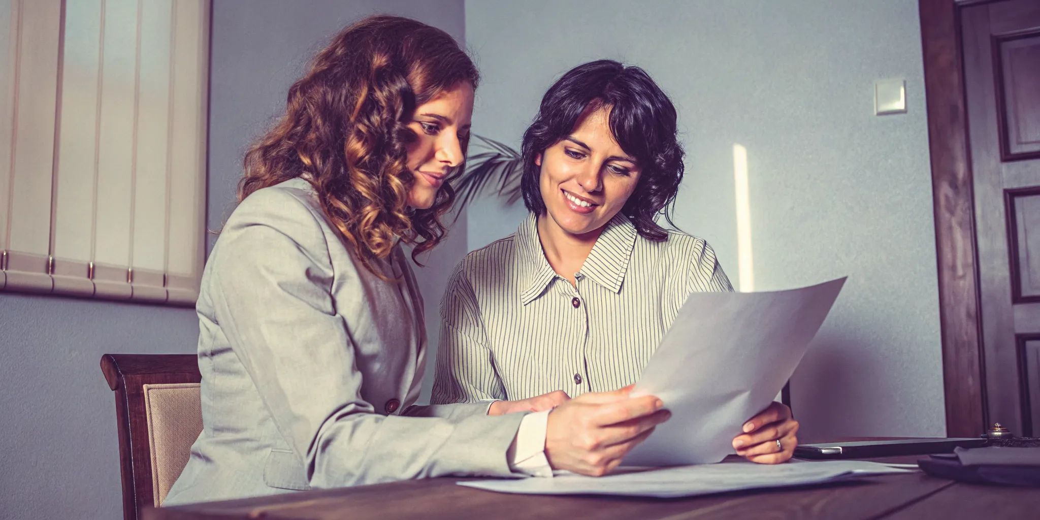 Attorney and plaintiff reviewing funding terms together over a desk in an office